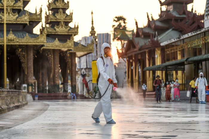 Petugas menyemprotkan disinfektan di komplek Pagoda Shwedagon di Yangon, Myanmar.  
