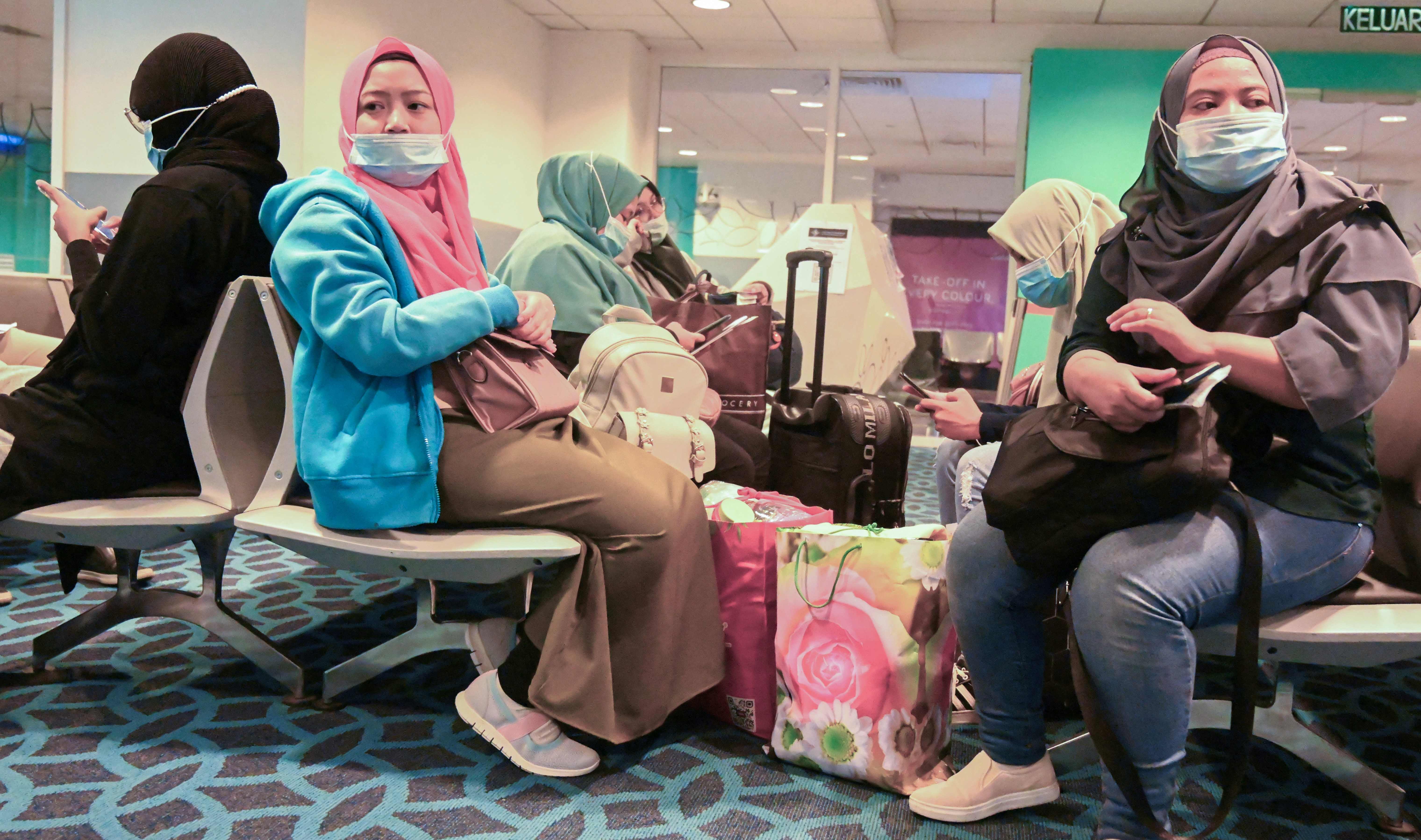 Sejumlah calon penumpang mengenakan masker di bandara internasional Kuala Lumpur, Malaysia.