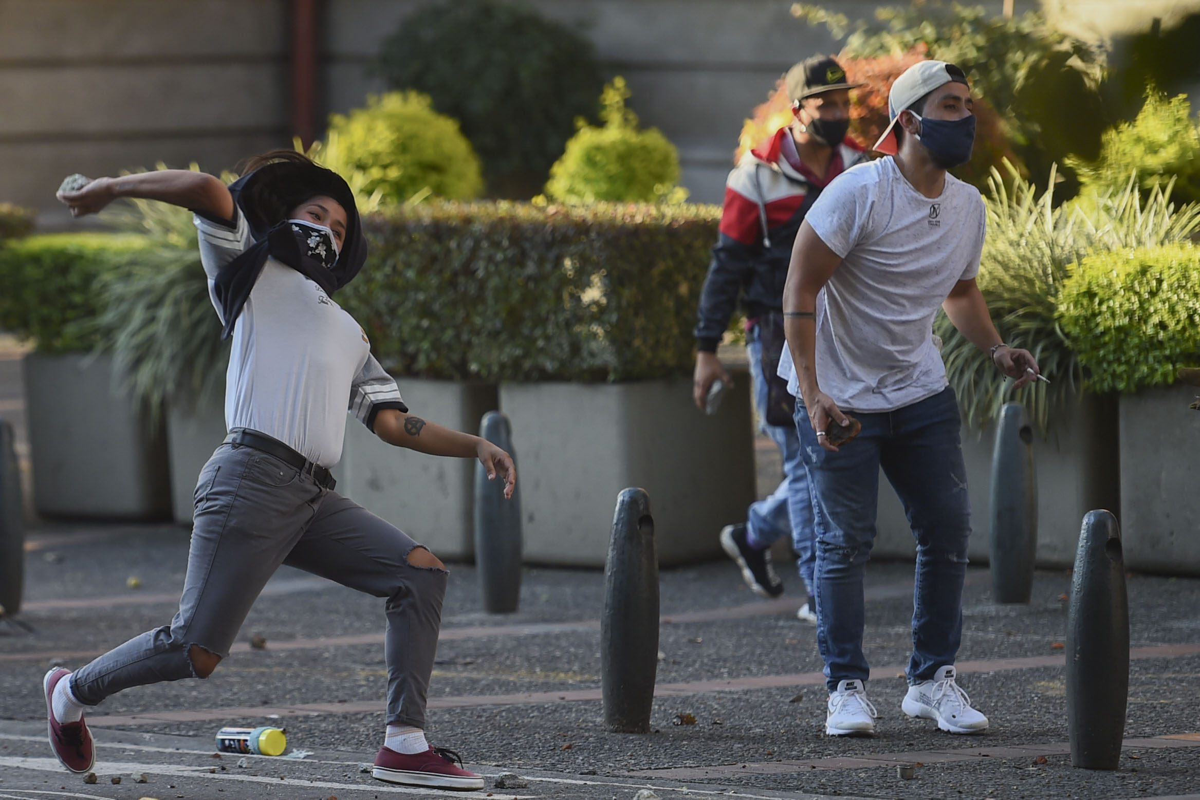 Demonstran melemparkan batu ke arah polisi di Medellin, Kolombia.