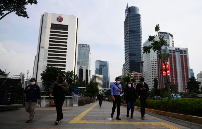Di tengah penerapan PSBB, sejumlah pekerja berjalan di kawasan gedung perkantoran Jakarta.