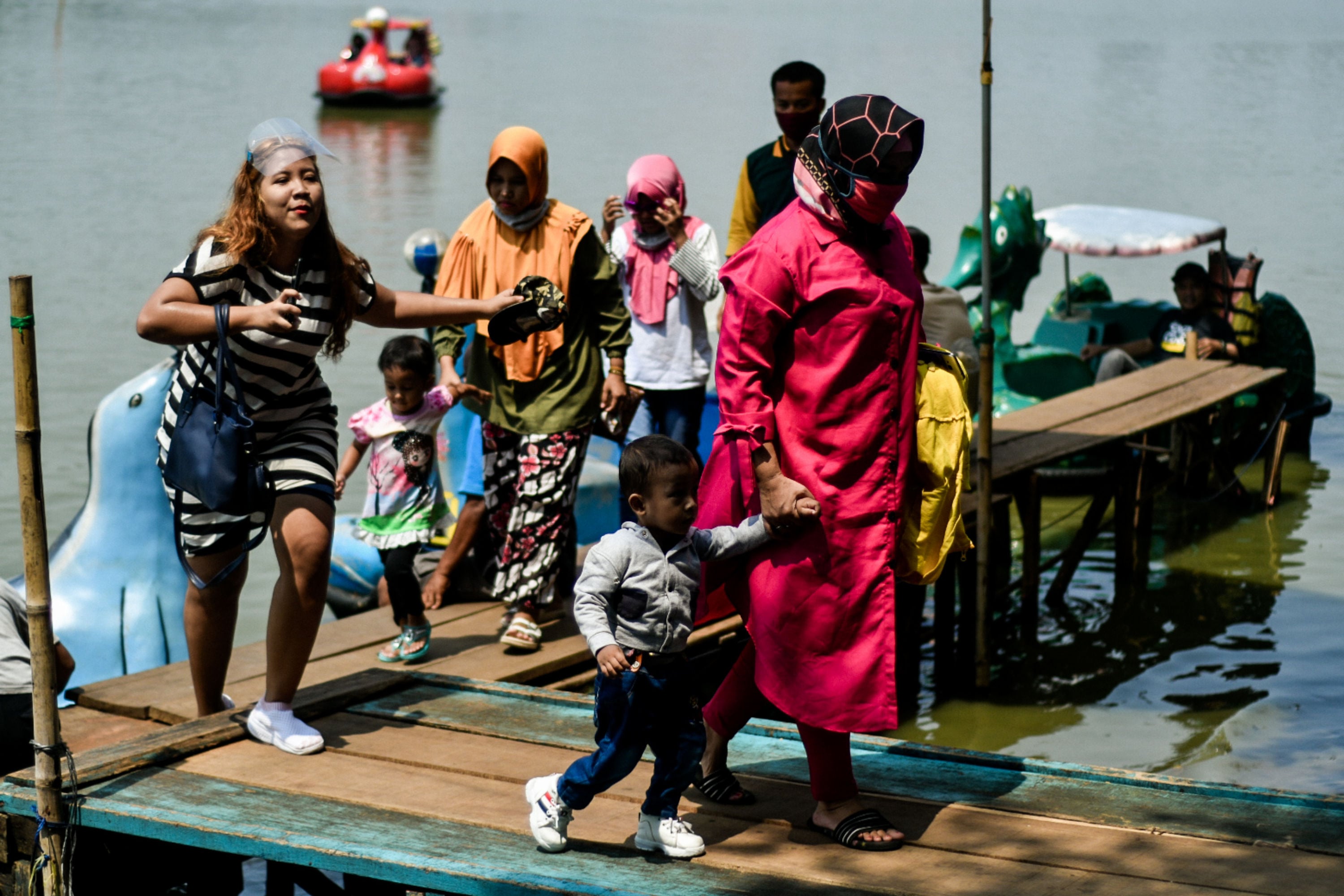 Warga memanfaatkan libur akhir pekan di kawasan wisata Perkampungan Budaya Betawi (PBB) Setu Babakan, Jakarta Selatan, Minggu (13/9/2020). 