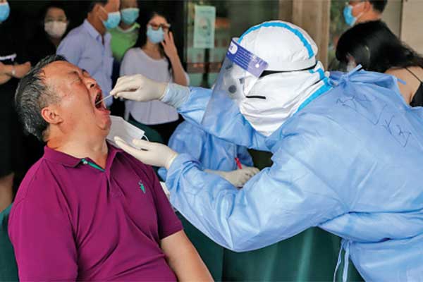 Petugas kesehatan melakukan tes usap (swab test) covid-19 terhadap warga di Kota Ruili, Provinsi Yunnan, Tiongkok