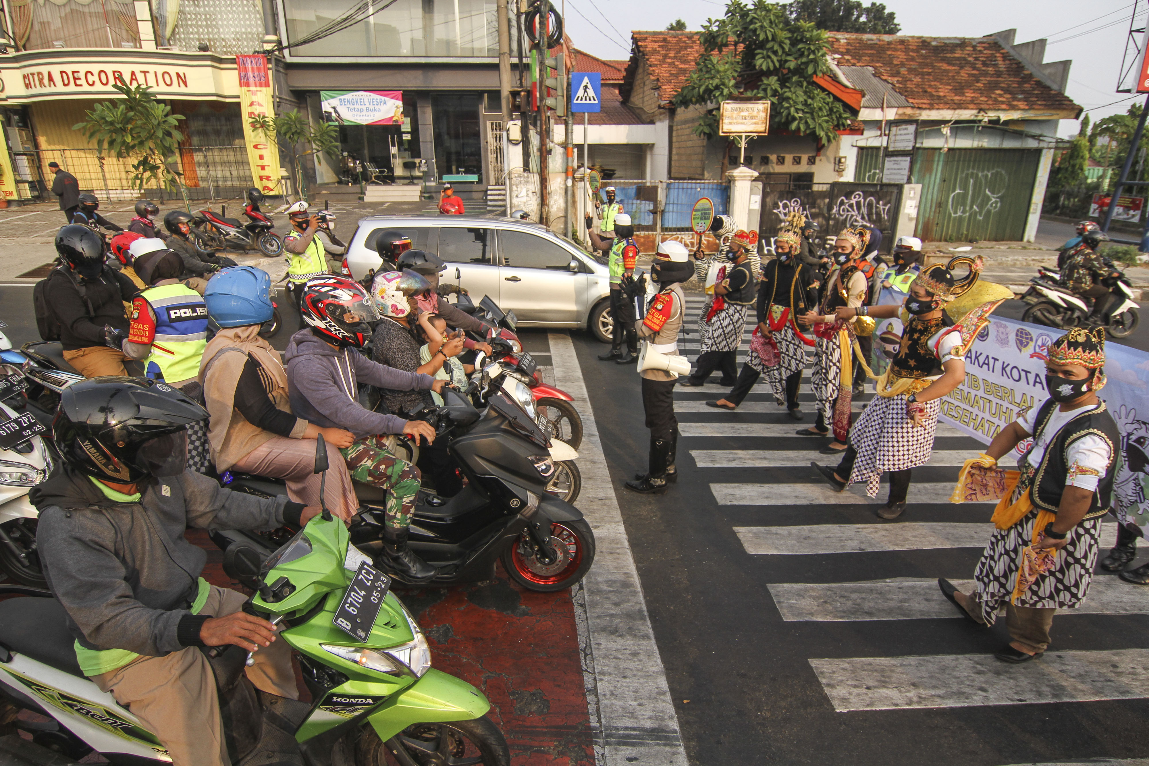 Polantas dengan pakaian tokoh wayang melakukan sosialisasi penggunaan masker di Jalan Raya Margonda, Depok, Jawa Barat, Senin (14/9).