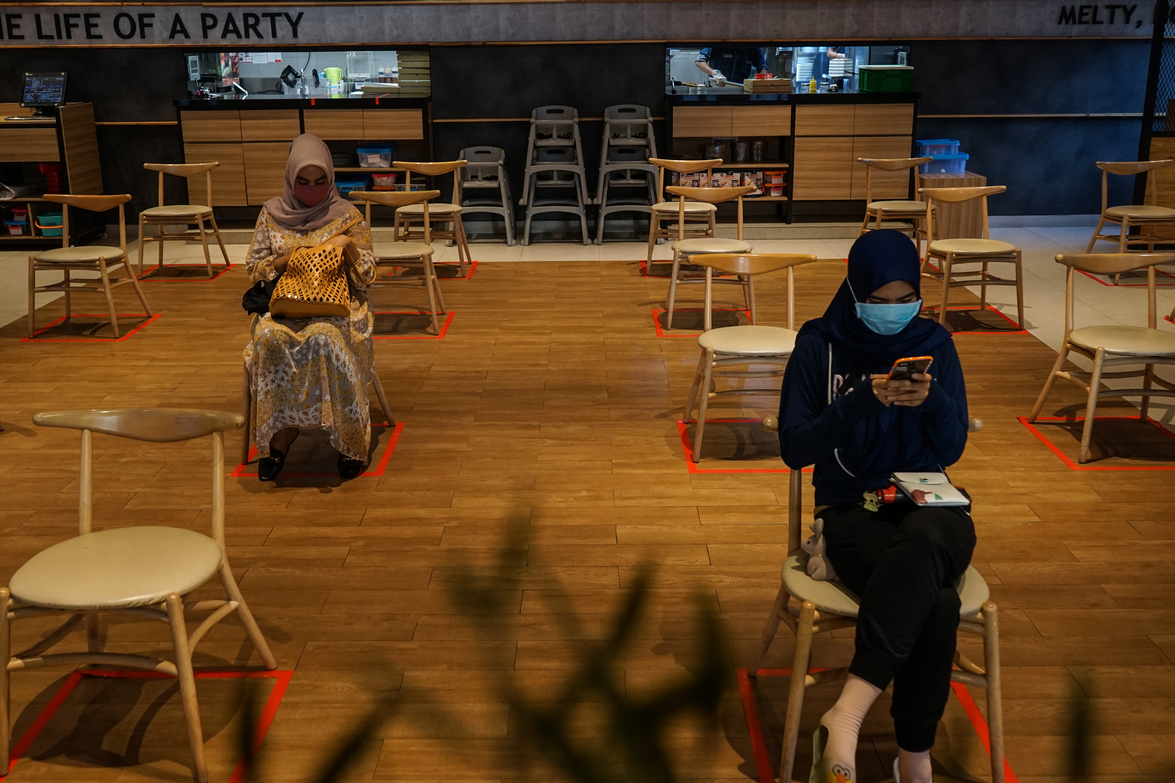 Pelanggan menunggu pesanan dengan menjaga jarak fisik di salah satu restoran cepat saji di Banjarmasin, Kalimantan Selatan.