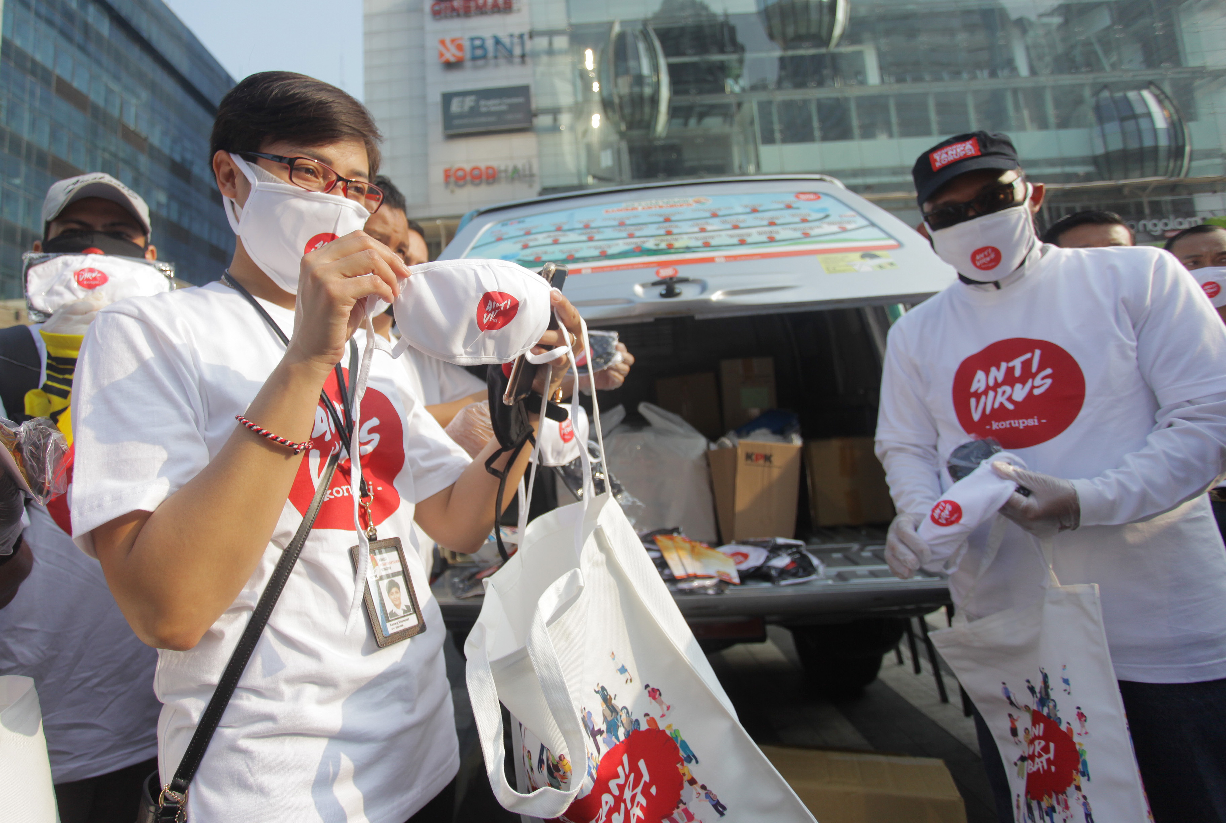 Sejumlah pegawai KPK bersiap membagikan masker bertuliskan Antivirus Korupsi secara gratis ke pengendara yang melintas di Jalan Sudirman.
