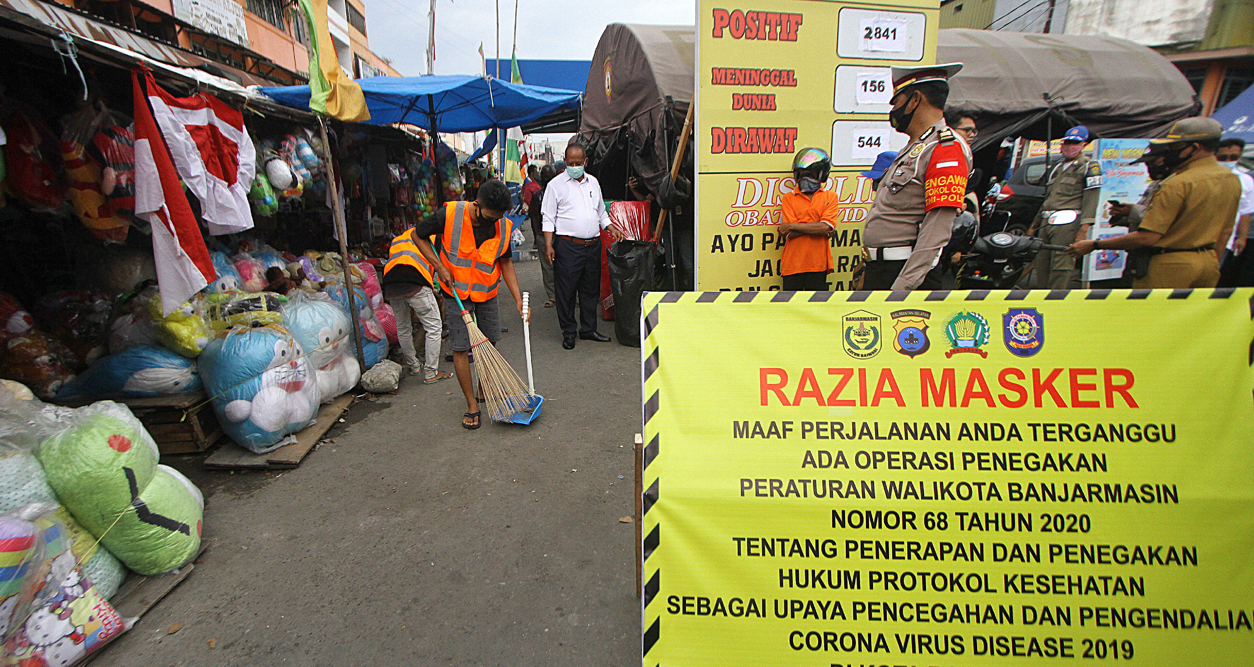  Pelanggar protokol kesehatan mendapatkan sanksi kerja sosial menyapu jalan di kawasan Pasar Lima Banjarmasin, Kalimantan Selatan.