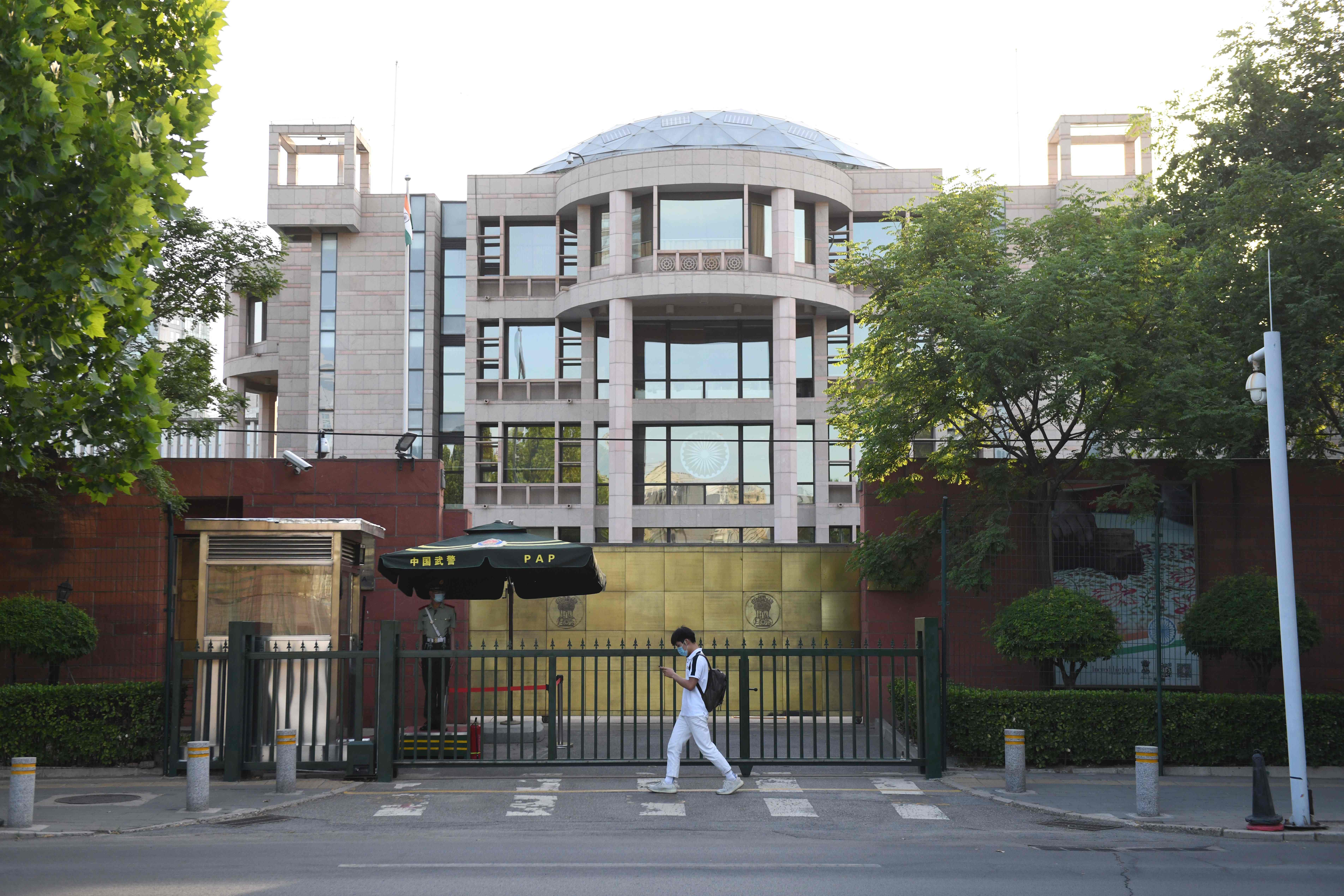 Seorang pria berjalan melewati pintu masuk kedutaan besar India di Beijing pada 16 Juni 2020. 