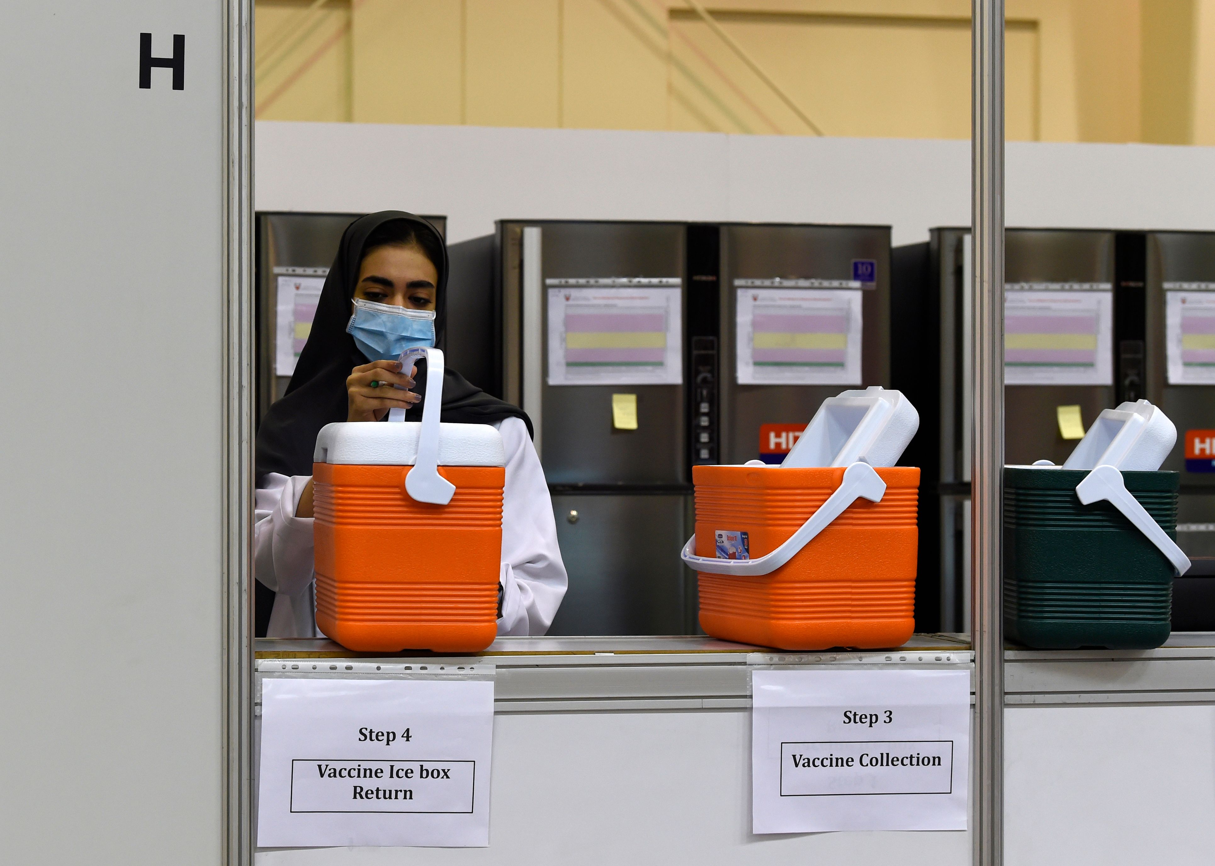 Seorang petugas menyiapkan vaksin covid-19 produksi Sinopharm yang akan disuntikkan kepada relawan di Bahrain.