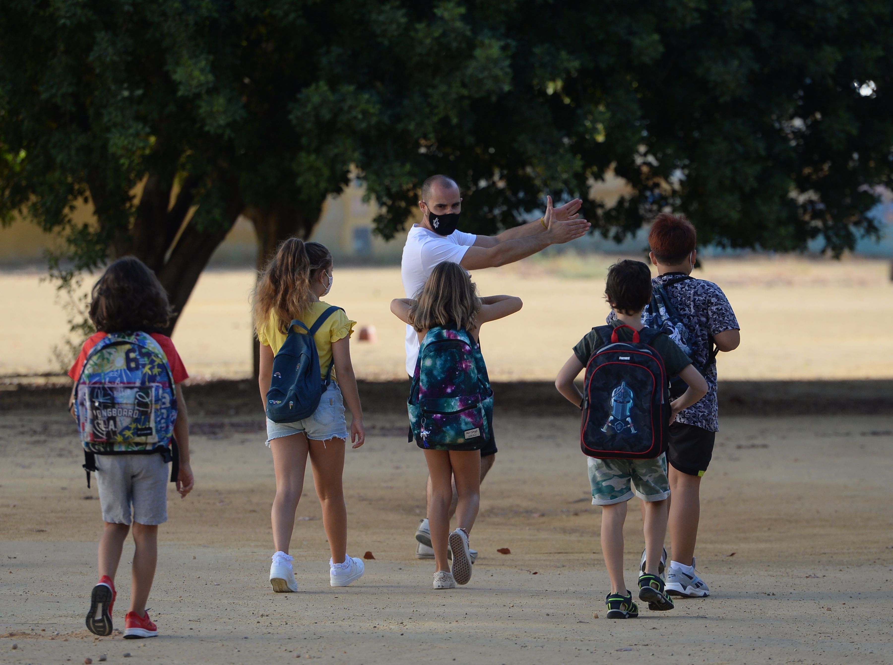 Seorang guru menyambut para murid yang kembali ke sekolah di Mairena del Aljarafe, Spanyol.