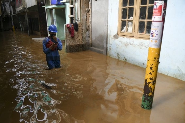 Warga berjalan melintasi banjir di Kebon Pala, Jatinegara, Selasa (22/9). Banjir tersebut terjadi karena luapan Sungai Ciliwung.  