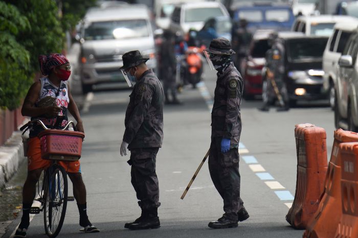 Polisi di Manila, Filipina, memeriksa pesepeda di tengah kebijakan pembatasan terkait covid-19.  