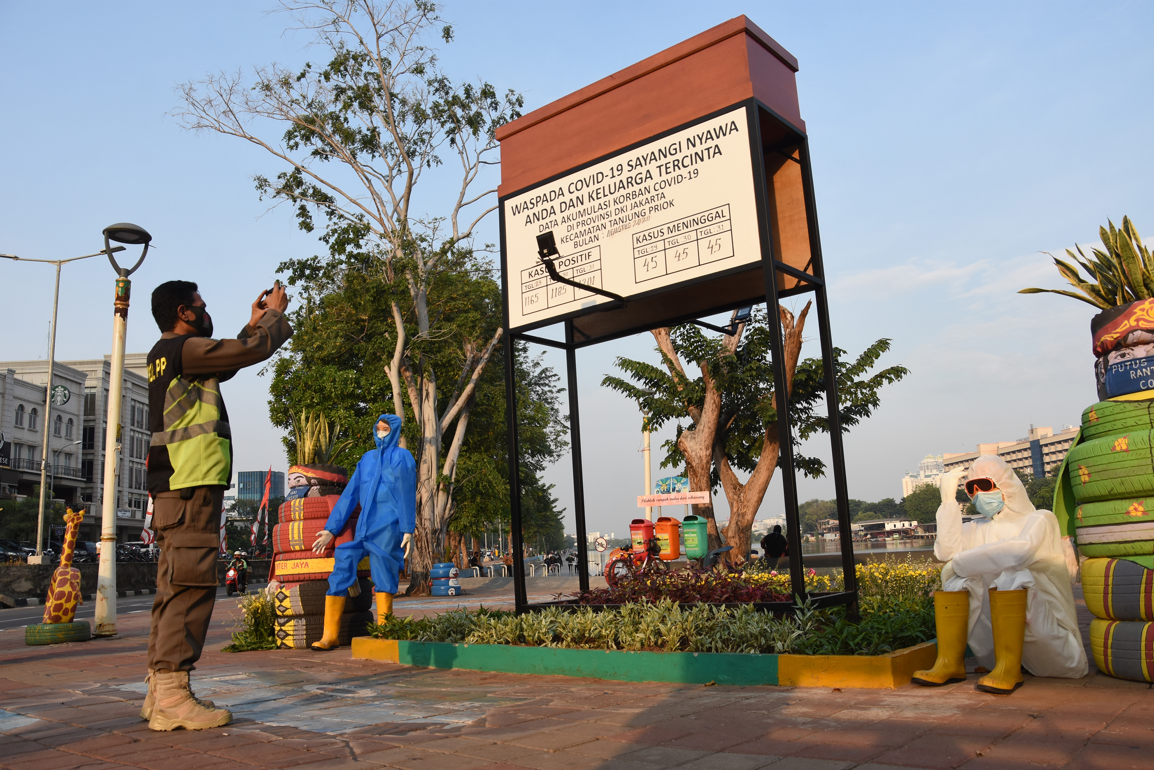  Petugas Satpol PP memotret data korban pada karya instalasi waspada COVID-19 di kawasan Danau Sunter, Jakarta, Rabu (2/9/2020). 