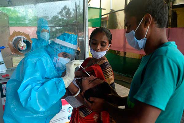 Petugas medis sedang melakukan swab test terhadap pasien di India