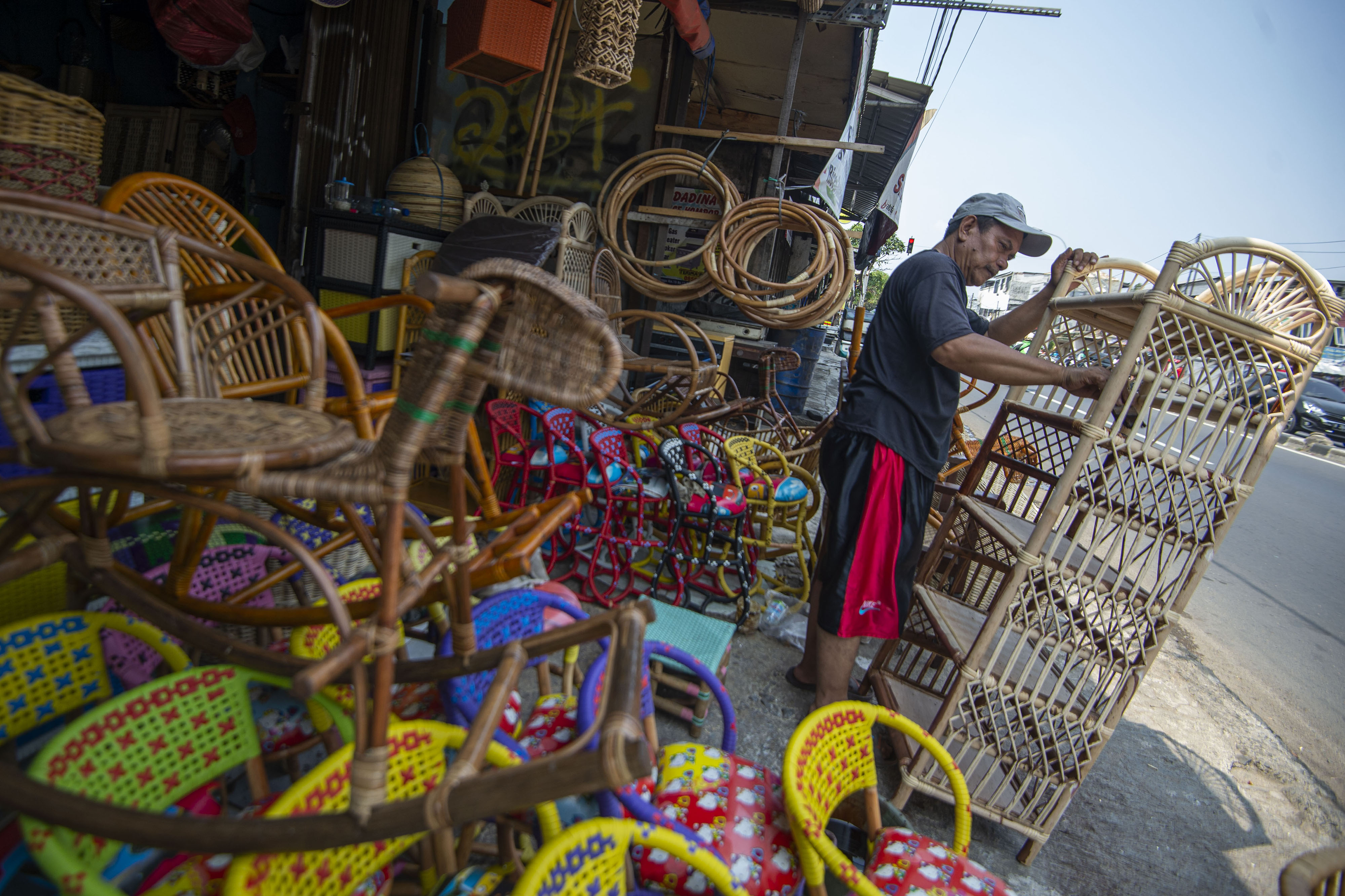Perajin menyelesaikan perabot berbahan rotan di kawasan Pasar Minggu, Jakarta.