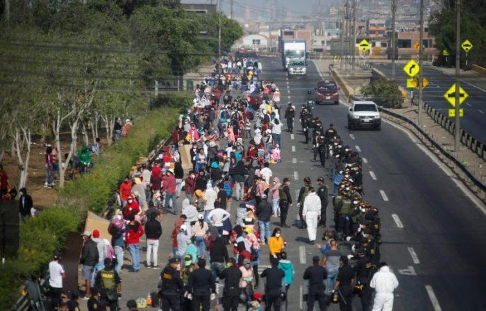 Petugas memblokade warga yang mencoba keluar dari Kota Lima, Peru, Sabtu (18/4/2020).  