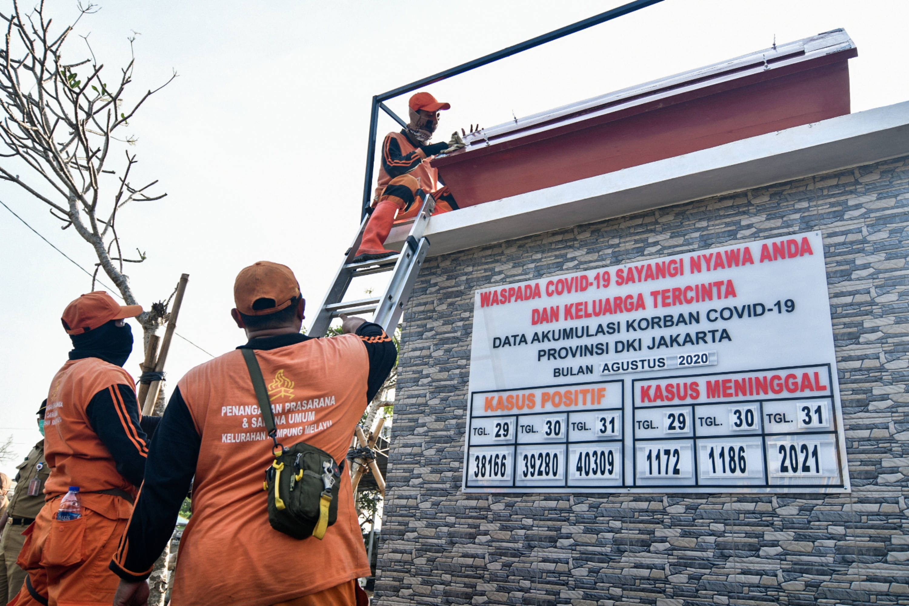 Petugas PPSU membersihkan monumen Simbol Peringatan COVID-19 di Taman Tongtek, Jatinegara, Jakarta.