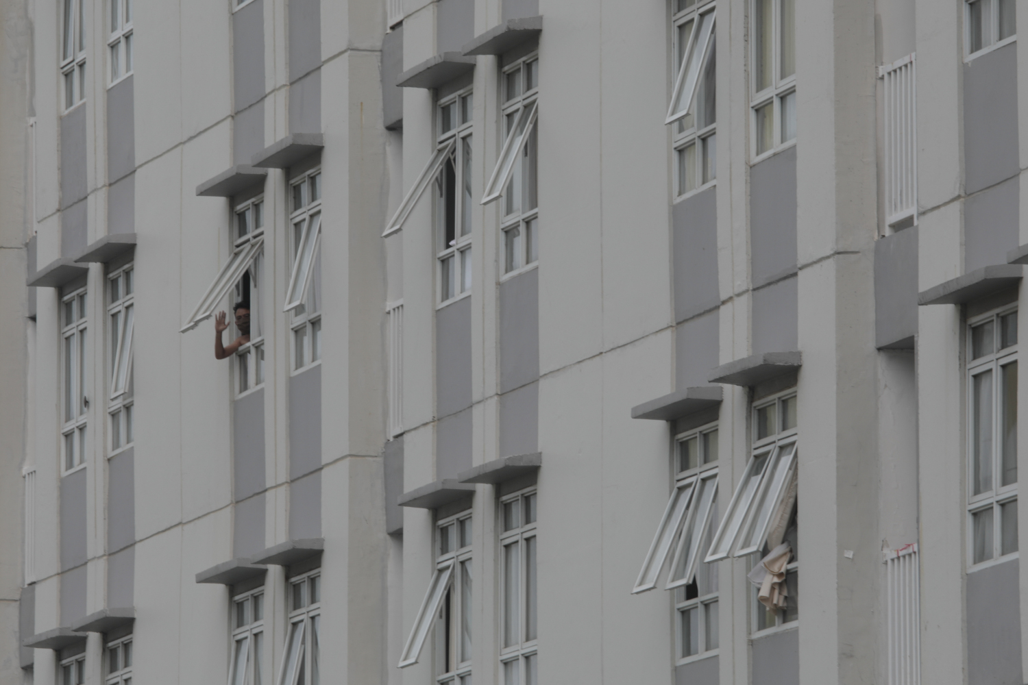 Pasien covid-19 yang dirawat di RSD Wisma Atlet tampak melambaikan tangan.