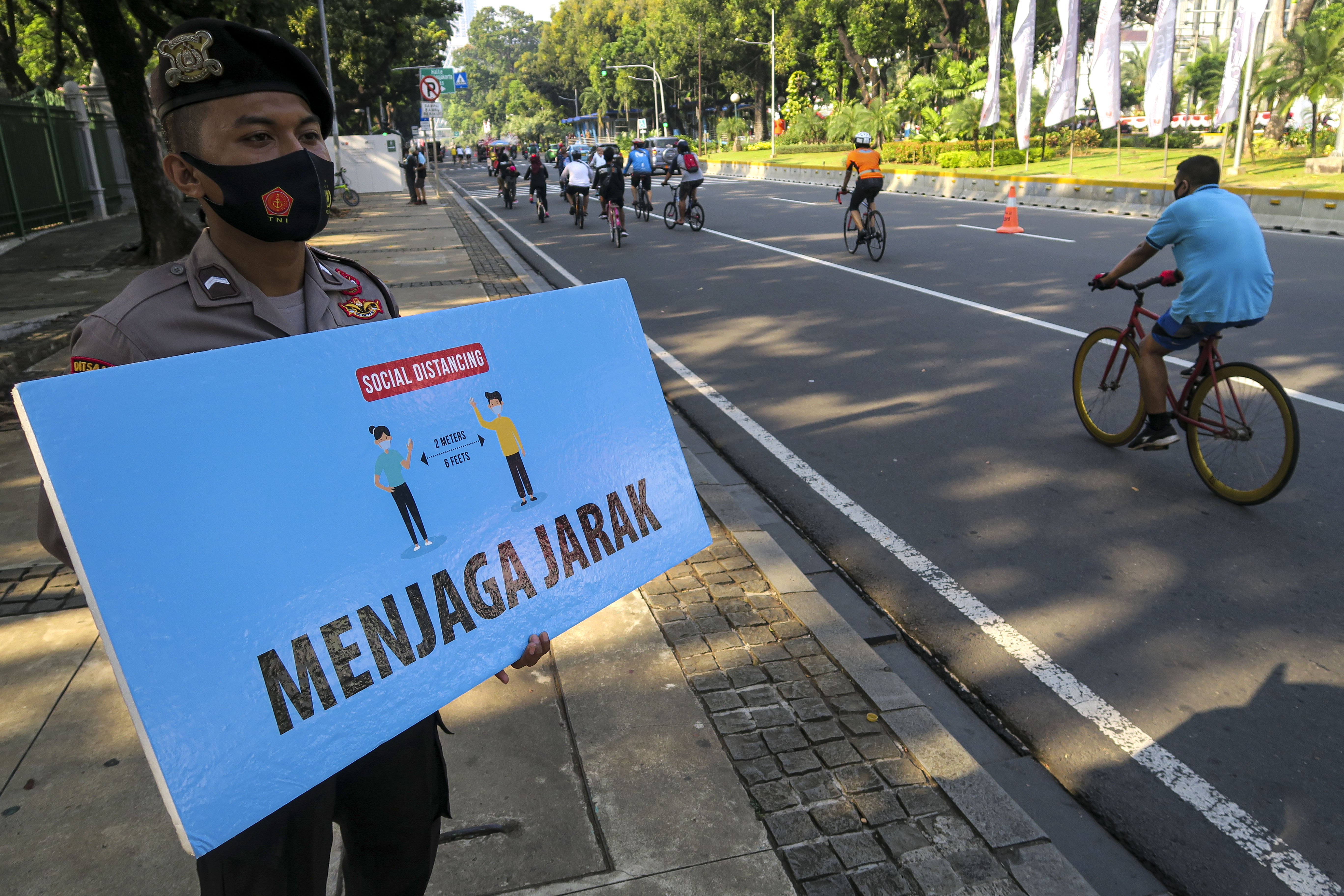 Petugas kepolisian memperingatkan warga menjaga jarak saat beraktivitas 