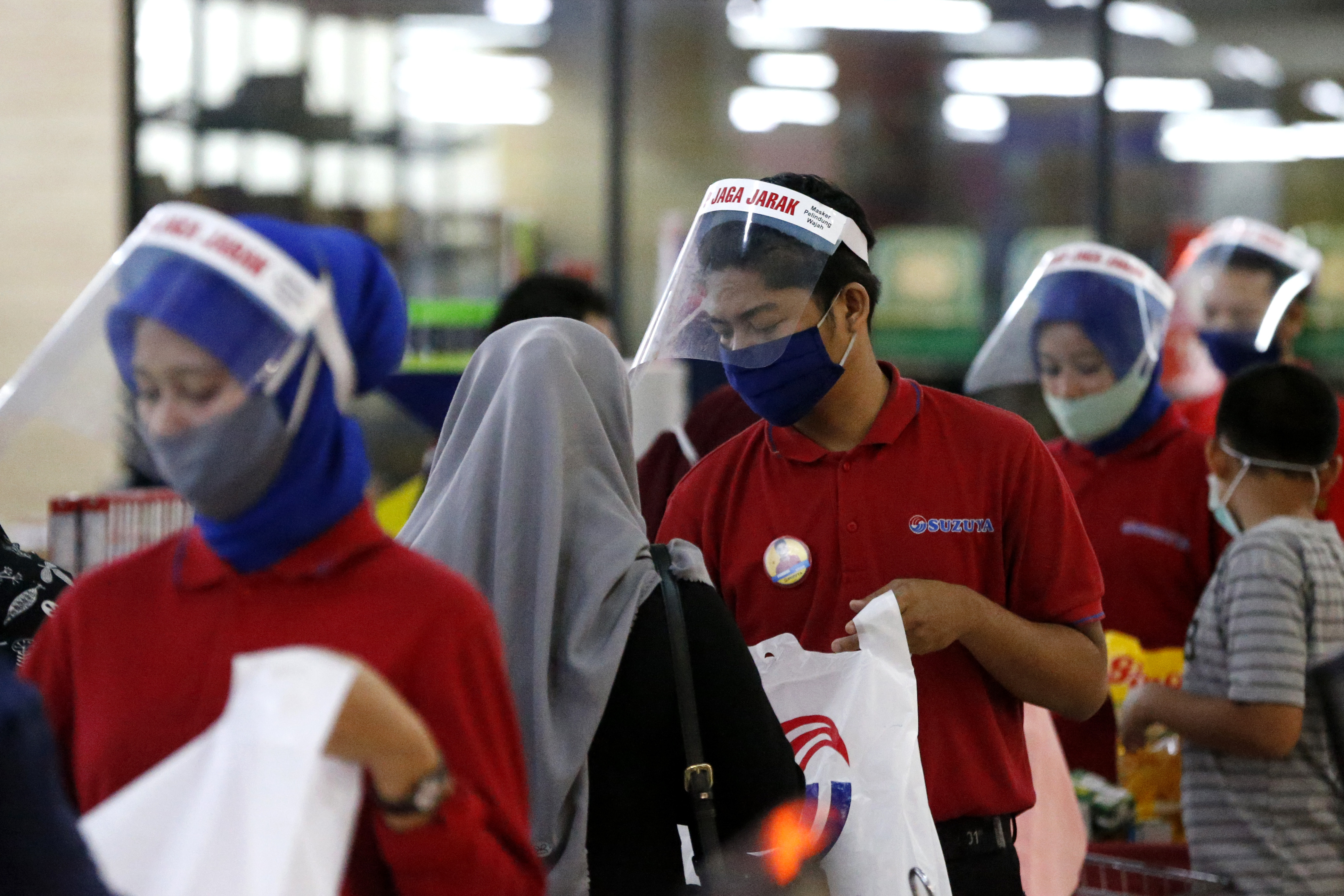 Petugas kasir di sebuah supermarket di Kota Banda Aceh memakai masker dan pelindung wajah.