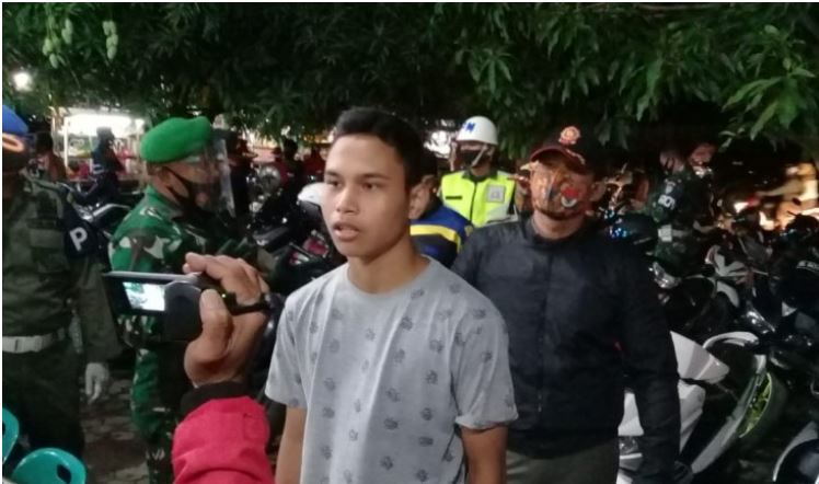 Seorang warga sedang membaca hafalan surah pendek Alquran akibat tidak mematuhi prokes di Simpang Mesra, Banda Aceh, Sabtu (19/9).