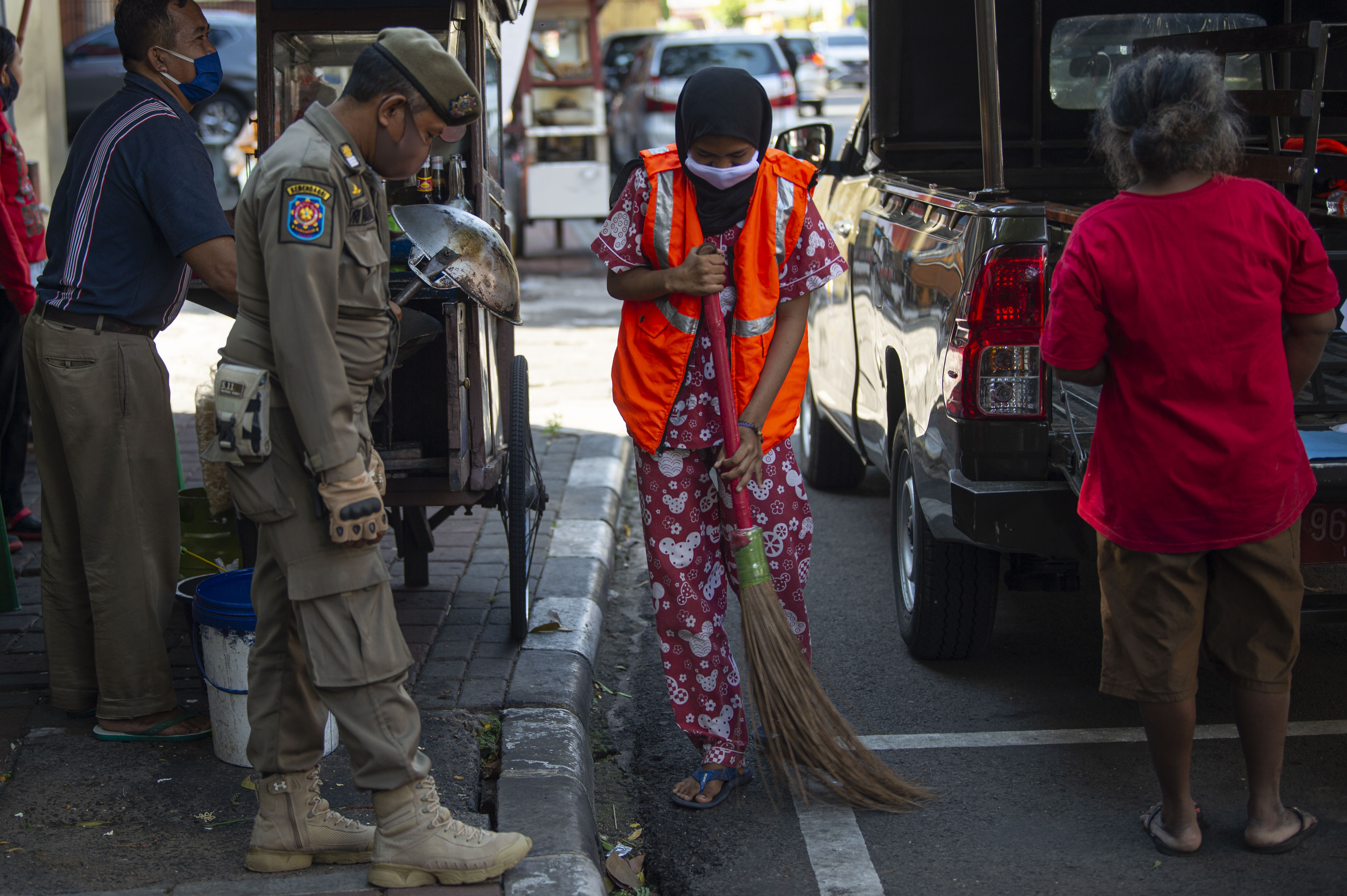 Warga yang tidak memakai masker dihukum menyapu di kawasan Juanda Jakarta