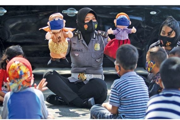 Ilustrasi -- Polwan memainkan boneka bermasker di hadapan anak-anak di kawasan rusun Kelurahan Dandangan, Kota Kediri, Jawa Timur, kemarin