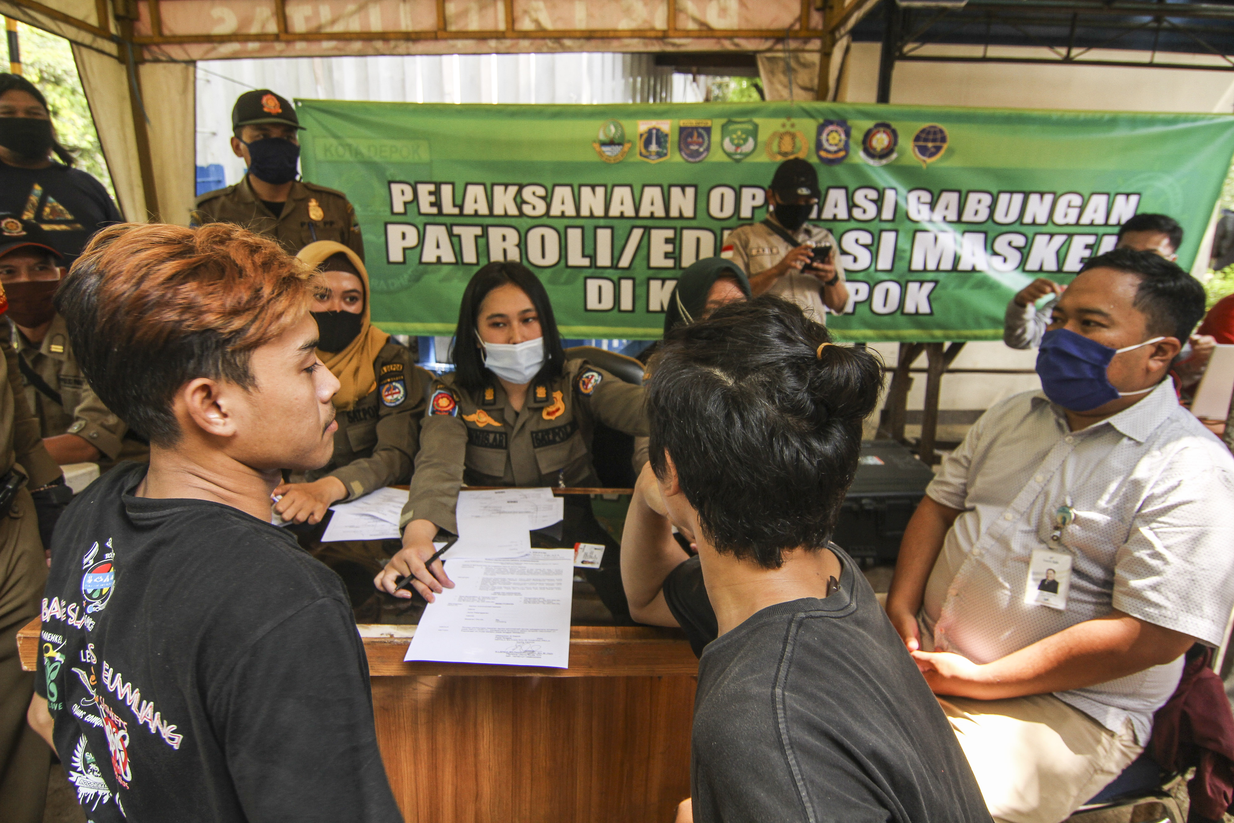 Petugas gabungan melakukan penindakan kepada warga yang tidak menggunakan masker di Simpang UI, Perbatasan Depok - Jakarta, Sabtu (5/9).