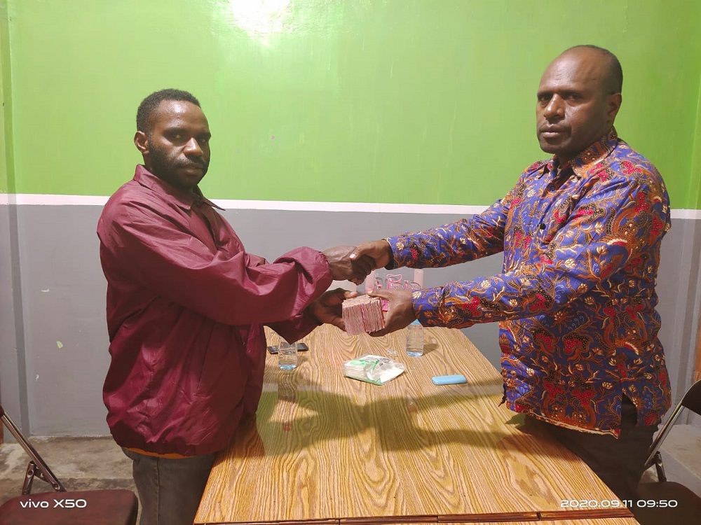 Kepala Bagian Ekonomi dan Pembangunan SDM Setda Kabupaten Tolikara, Yunius Tabuni,  menyerahkan bantuan kepada korwil mahasiswa Tolikara