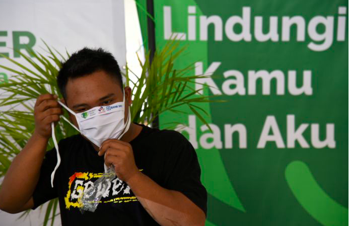 Pedagang pasar mengenakan masker yang diberikan Gerakan Pakai Masker