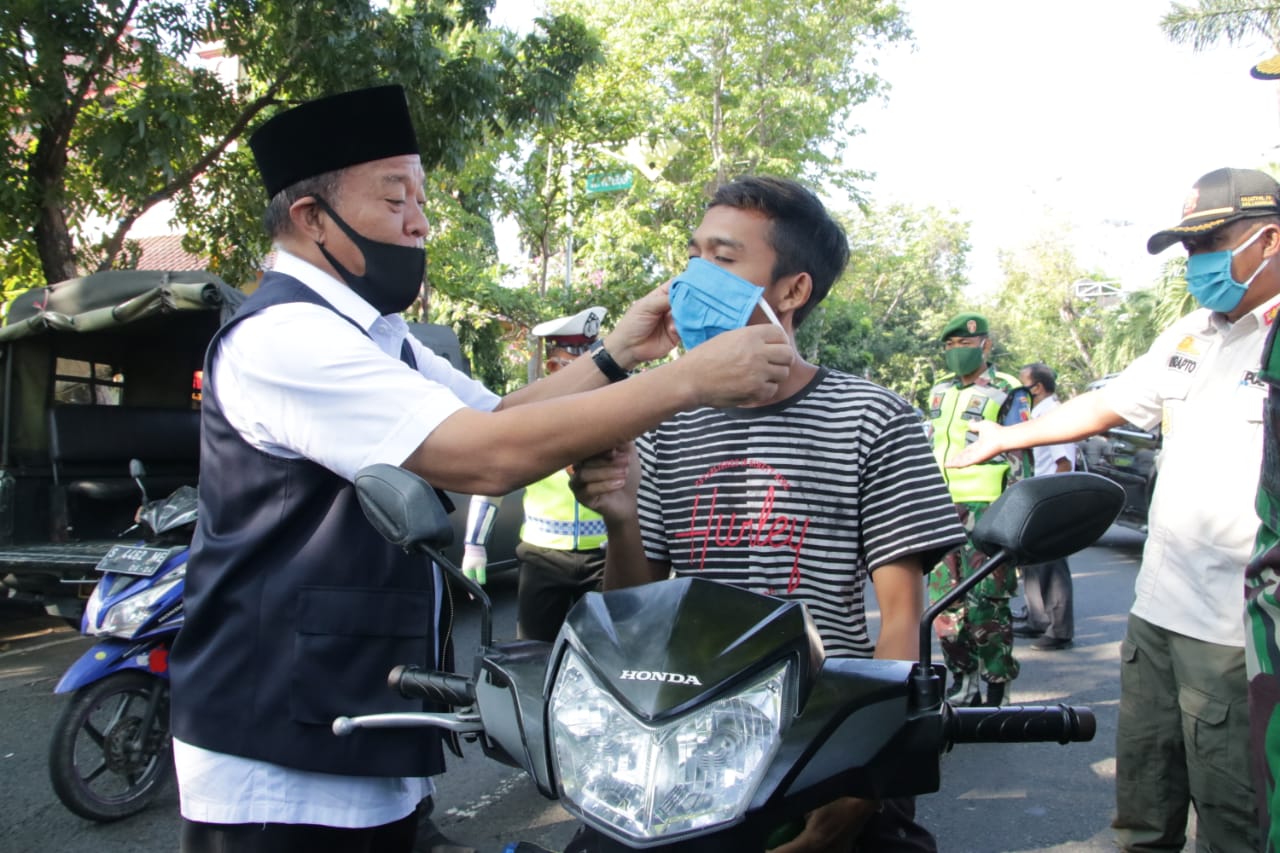 Tampak Bupati Lamongan Fadeli, membagikan masker dan sembako secara langsung kepada masyarakat.