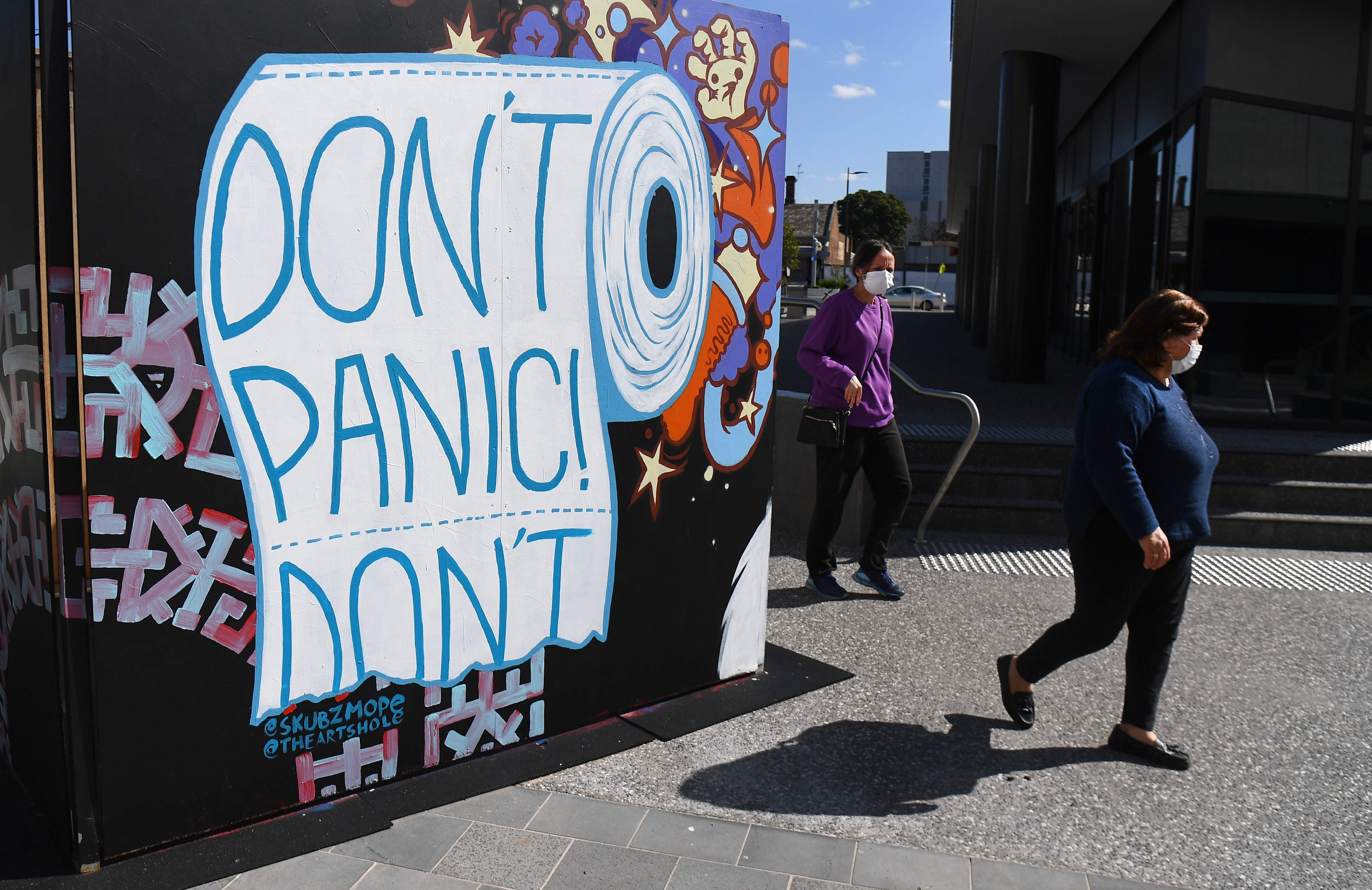 Warga melintasi mural terkait covid-19 di Melbourne, Australia.