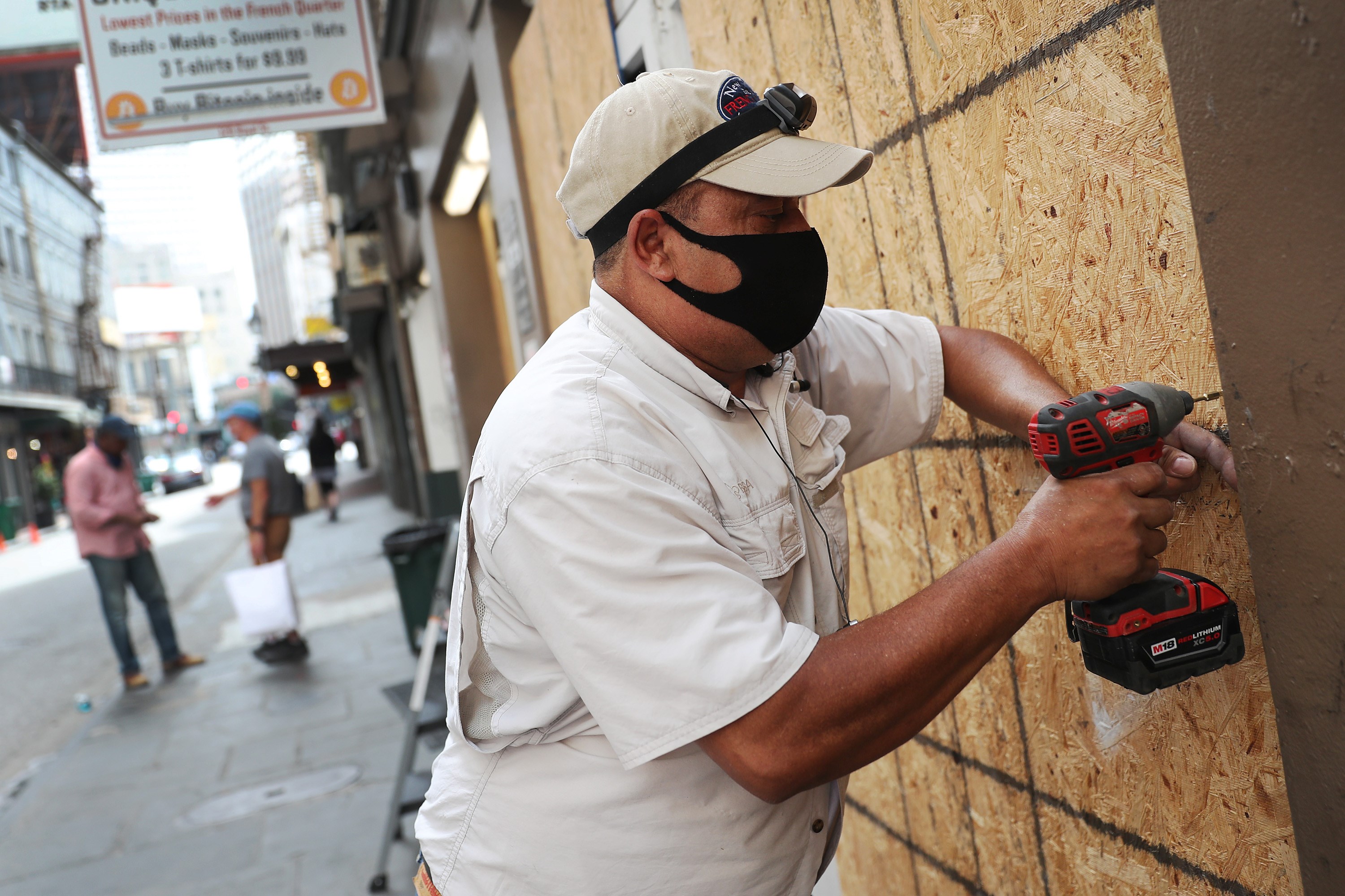 Luis A. Sanabria memasang kayu lapis untuk melindungi jendela toko di French Quarter, New Orleans, Louisiana (14/9/2020)