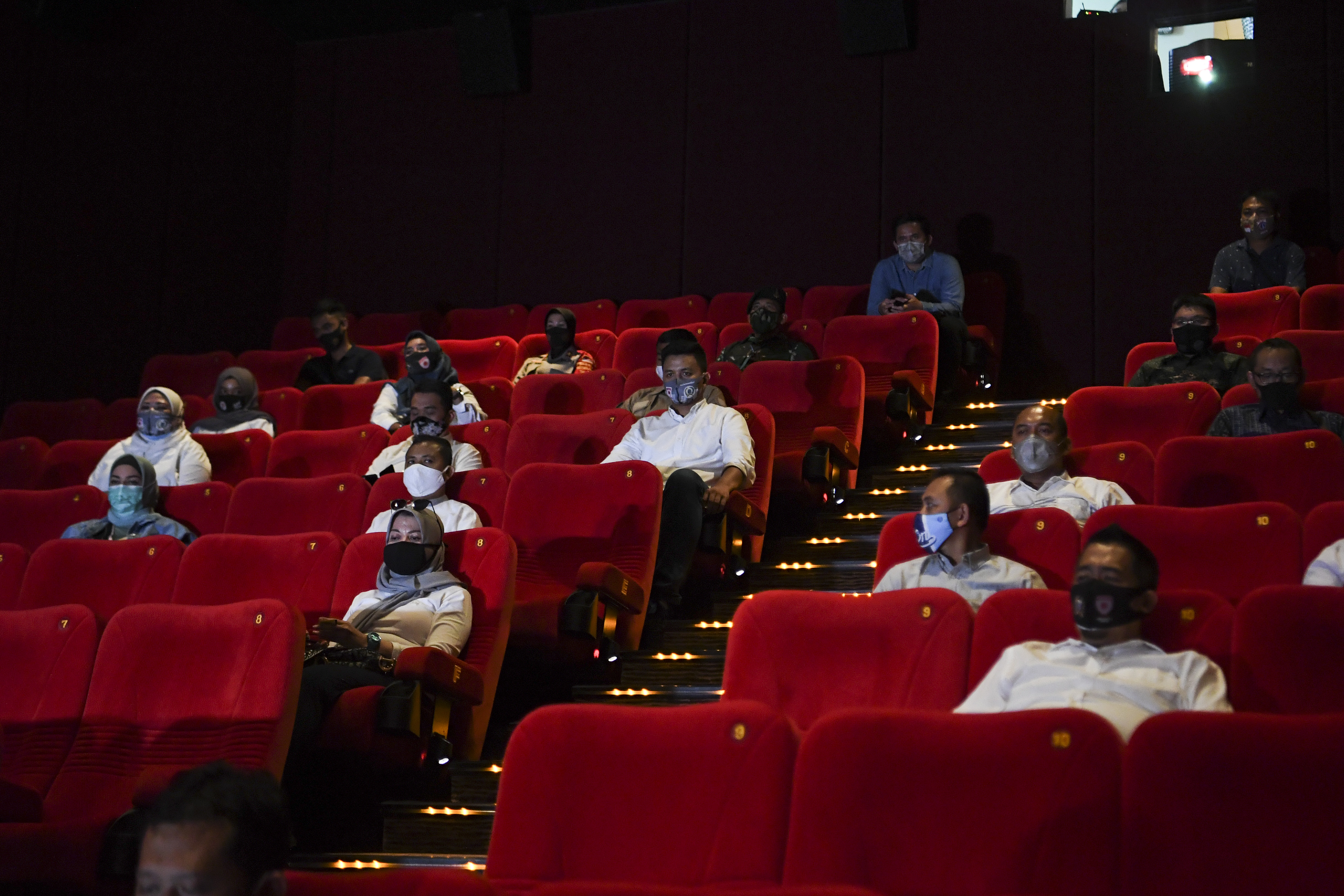 Penonton Bioskop XXI duduk berjaga jarak saat pemeriksaan kesiapan bioskop beroperasi kembali di Pusat Grosir Cililitan, Jakarta
