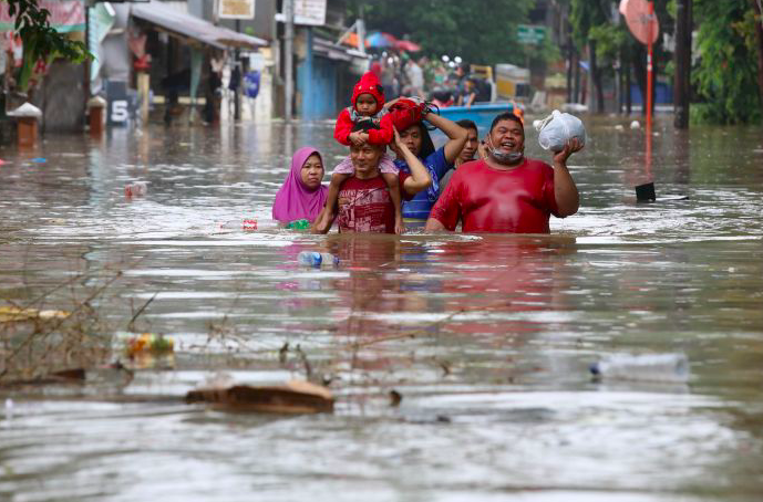 Warga menyelamatkan diri saat banjir melanda kawasan Bendungan Hilir, Jakarta. 
