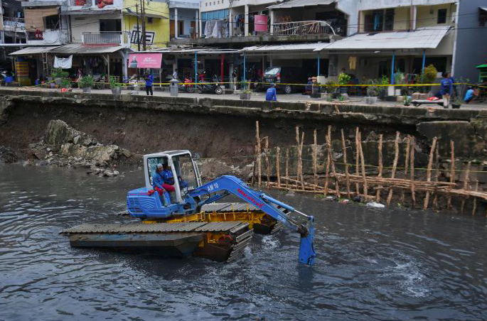 Petugas UPK Badan Air tengah memperbaiki turap Kali Sunter yang ambles di Jalan Cinta, Pulogadung, Jakarta Timur, Rabu (8/1)
