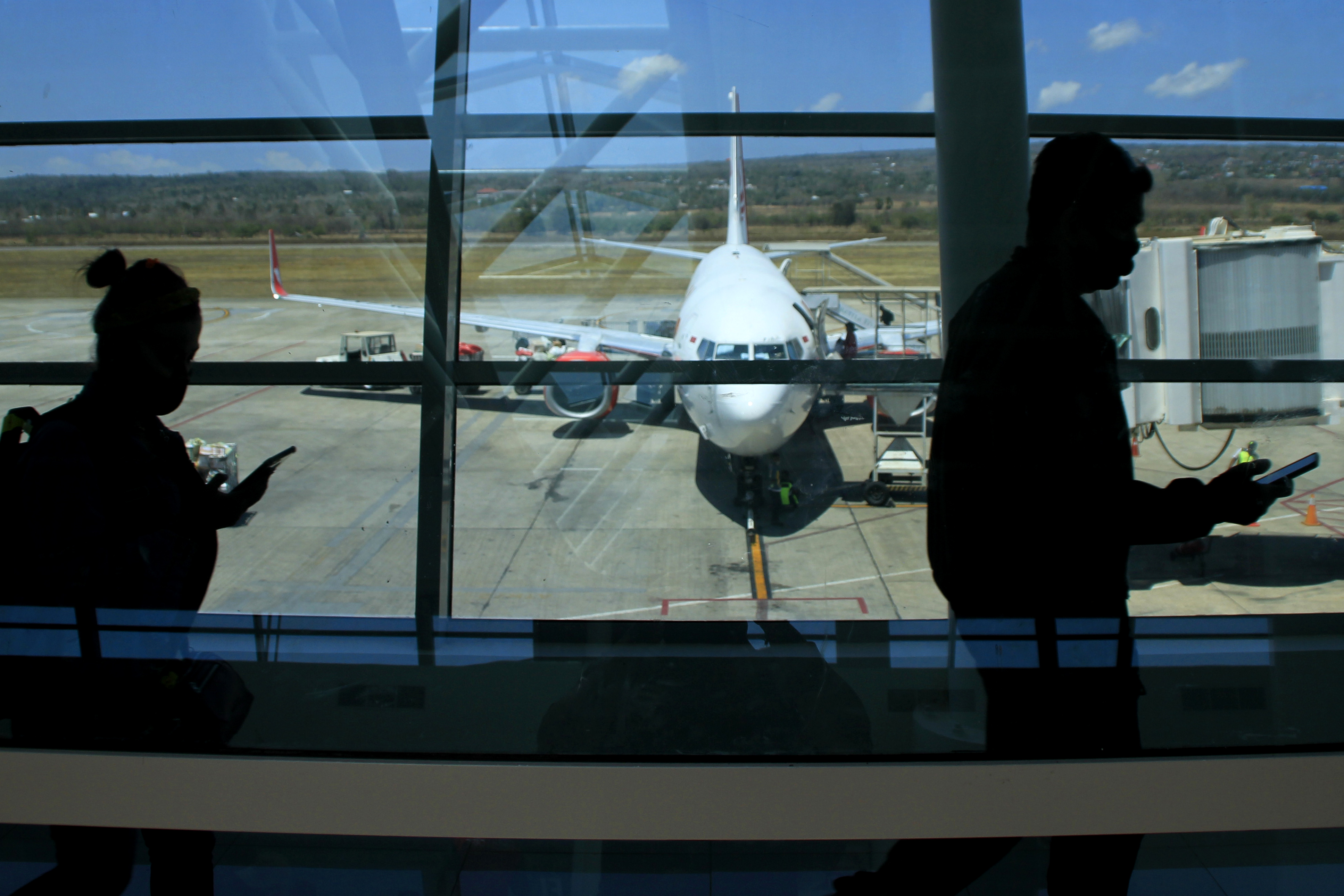 Siluet penumpang berjalan di koridor bandara