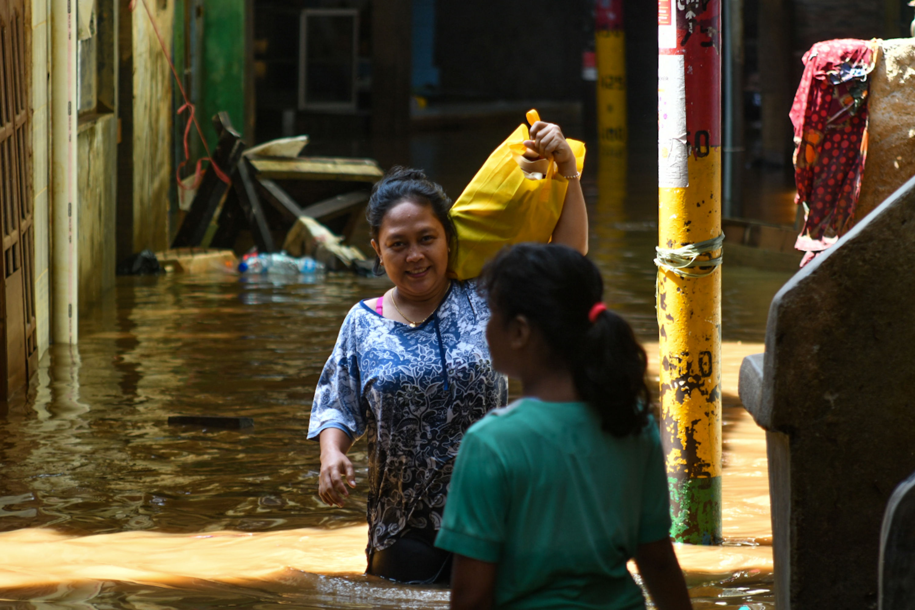 Warga melintasi banjir yang merendam Kawasan Kebon Pala, Jakarta, Senin (5/10/2020). 