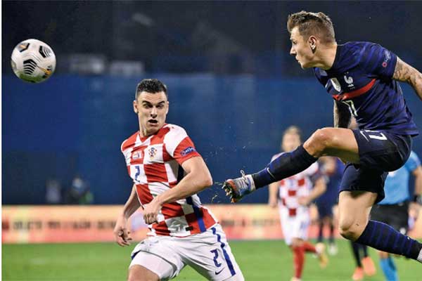 Bek Prancis Lucas Digne menyambut bola untuk mengamankan pertahanan dari serbuan pemain Kroasia 