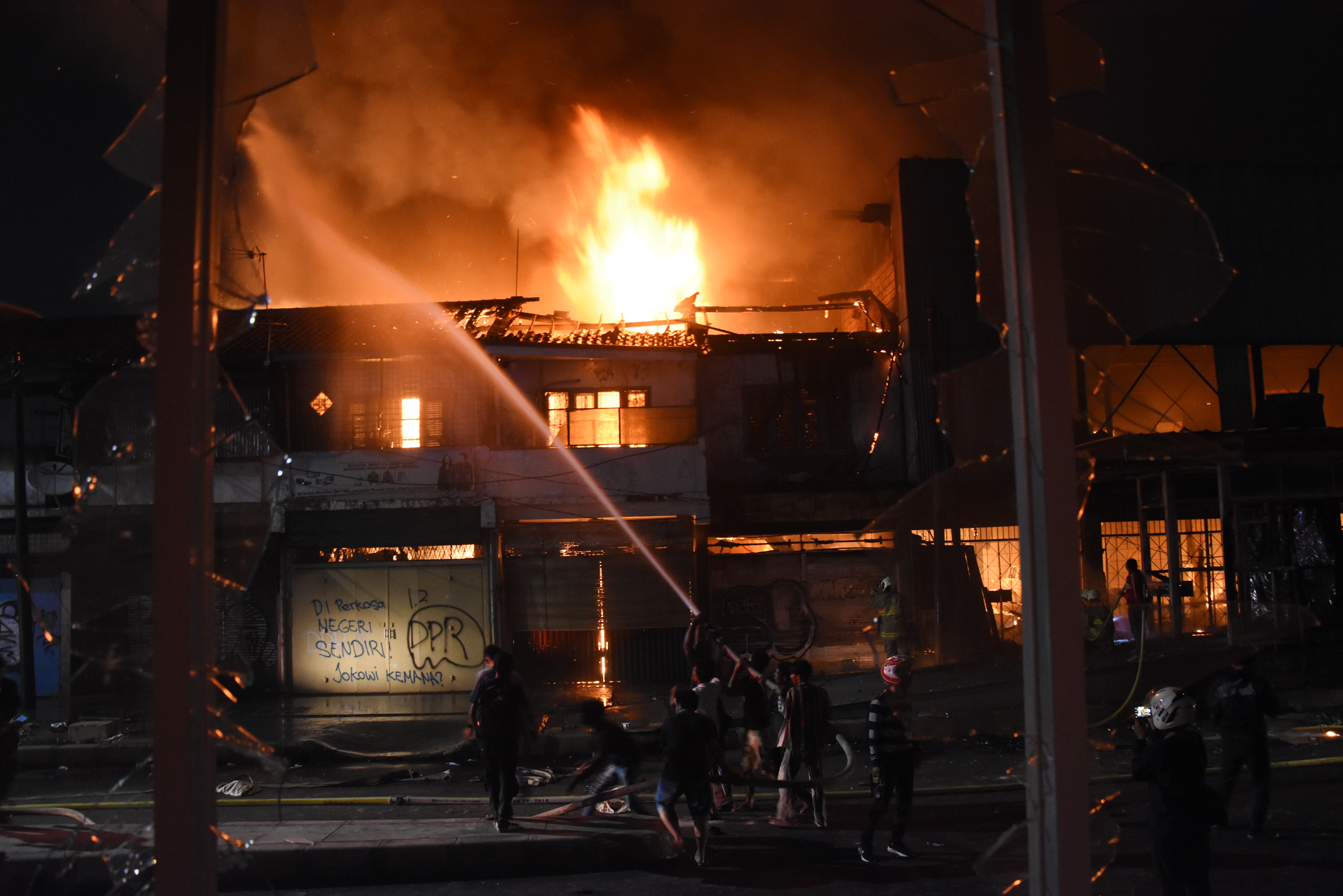 Petugas Pemadam Kebakaran dibantu warga memadamkan api yang menghanguskan bangunan di kawasan Senen, Jakarta, Kamis (8/10/2020) malam