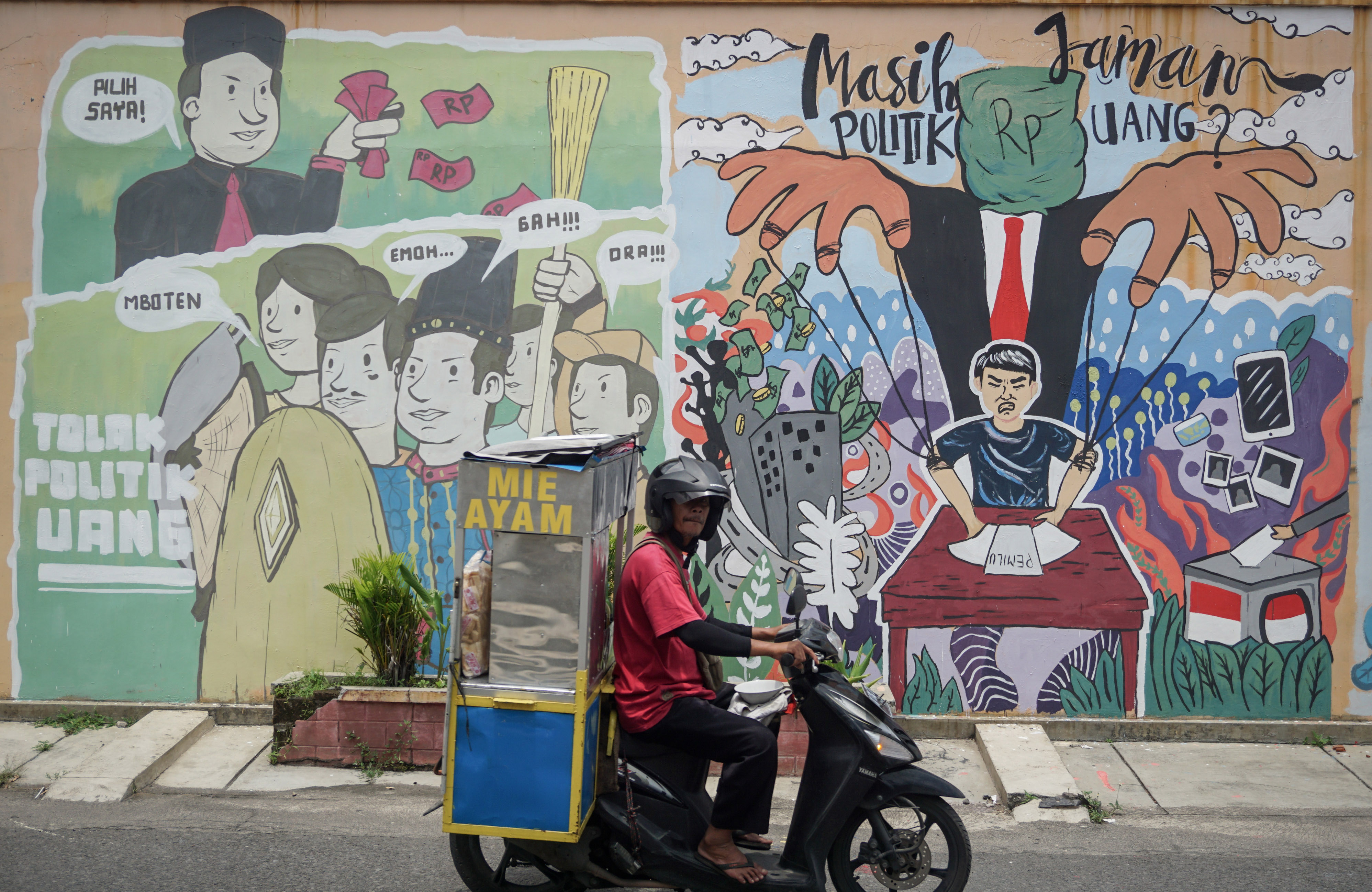 Warga melintasi mural terkait kampanye Pilkada 2020 di kawasan Laweyan, Solo.