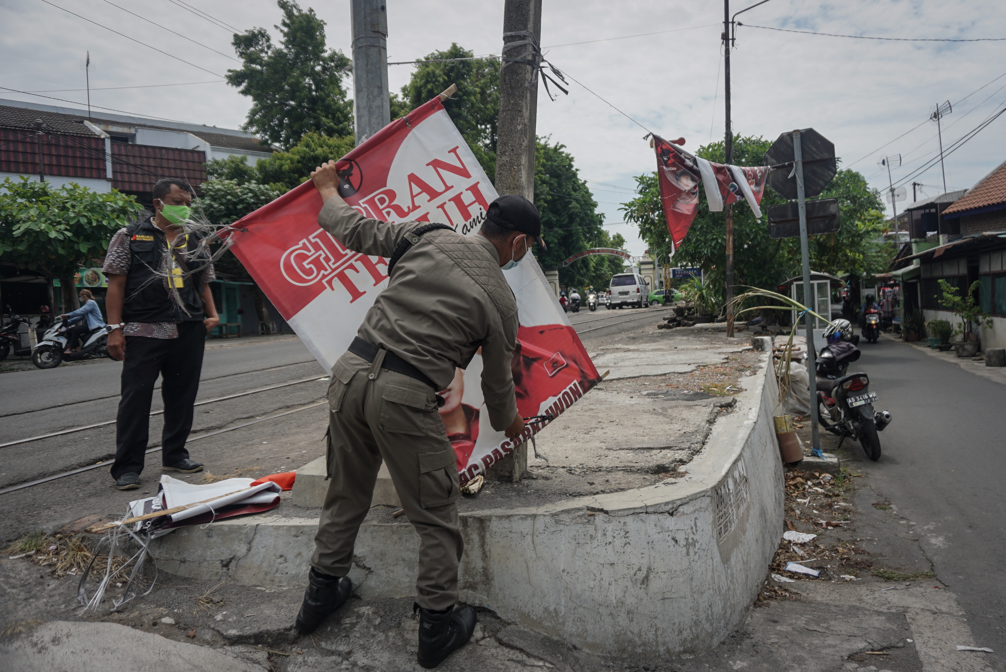 Personel Satpol PP mencopot Alat Peraga Kampanye (APK) saat penertiban di Pasar Kliwon, Solo, Jawa Tengah, kemarin.