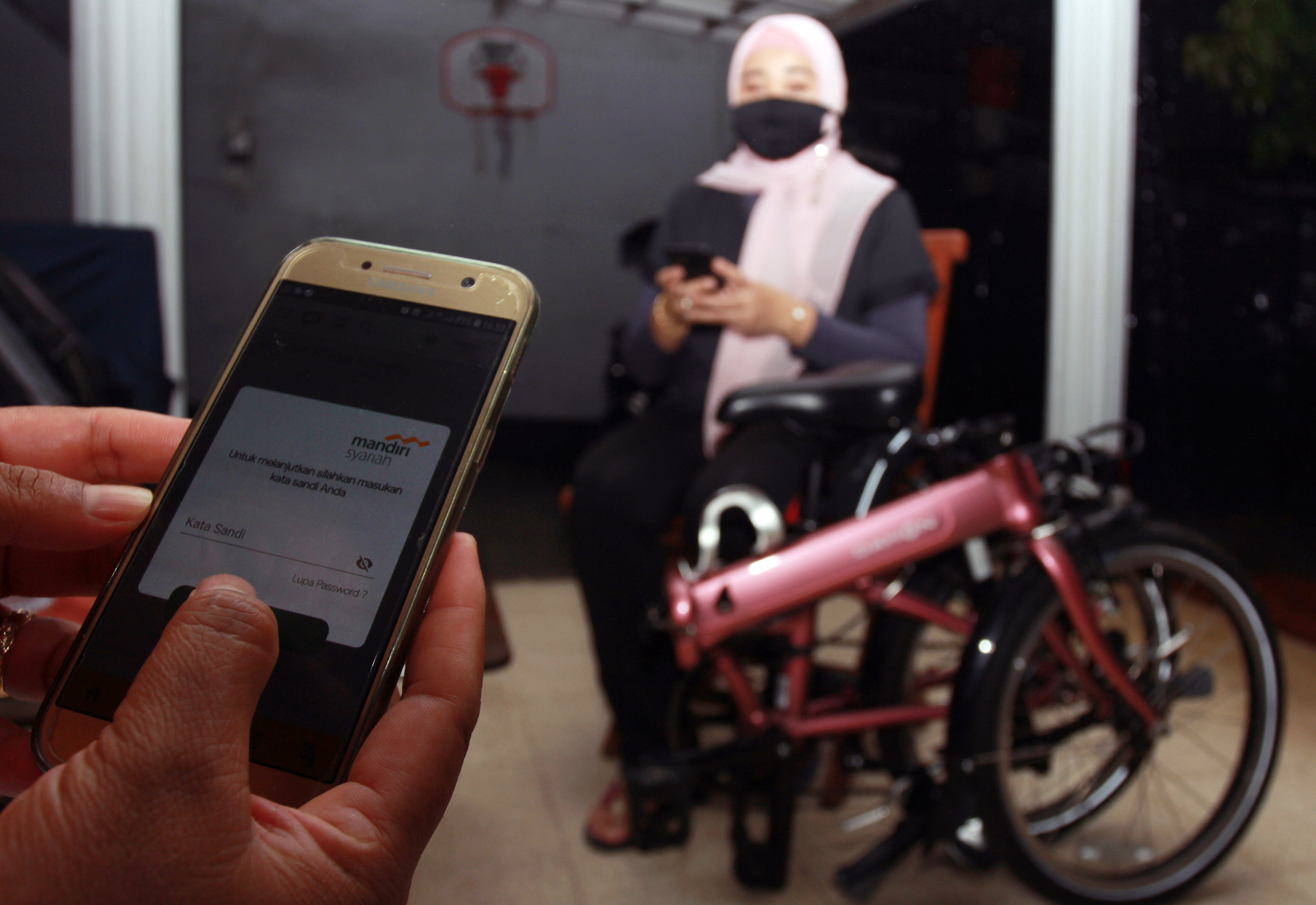 Seorang warga melakukan transaksi pembayaran pembelian barang secara cash on delivery (COD) dengan menggunakan Mandiri Syariah Mobile (MSM).