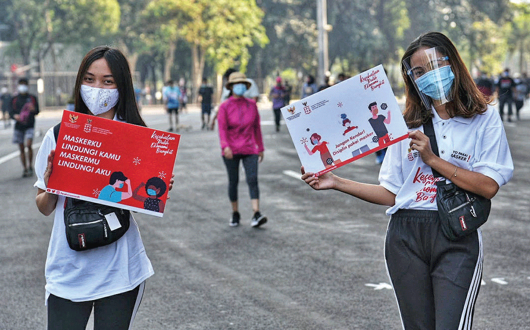 GERAKAN KAMPANYE MASKER NASIONAL: Dua remaja mengampanyekan gerakan memakai masker di Kompleks Gelora Bung Karno, Jakarta Pusat,  