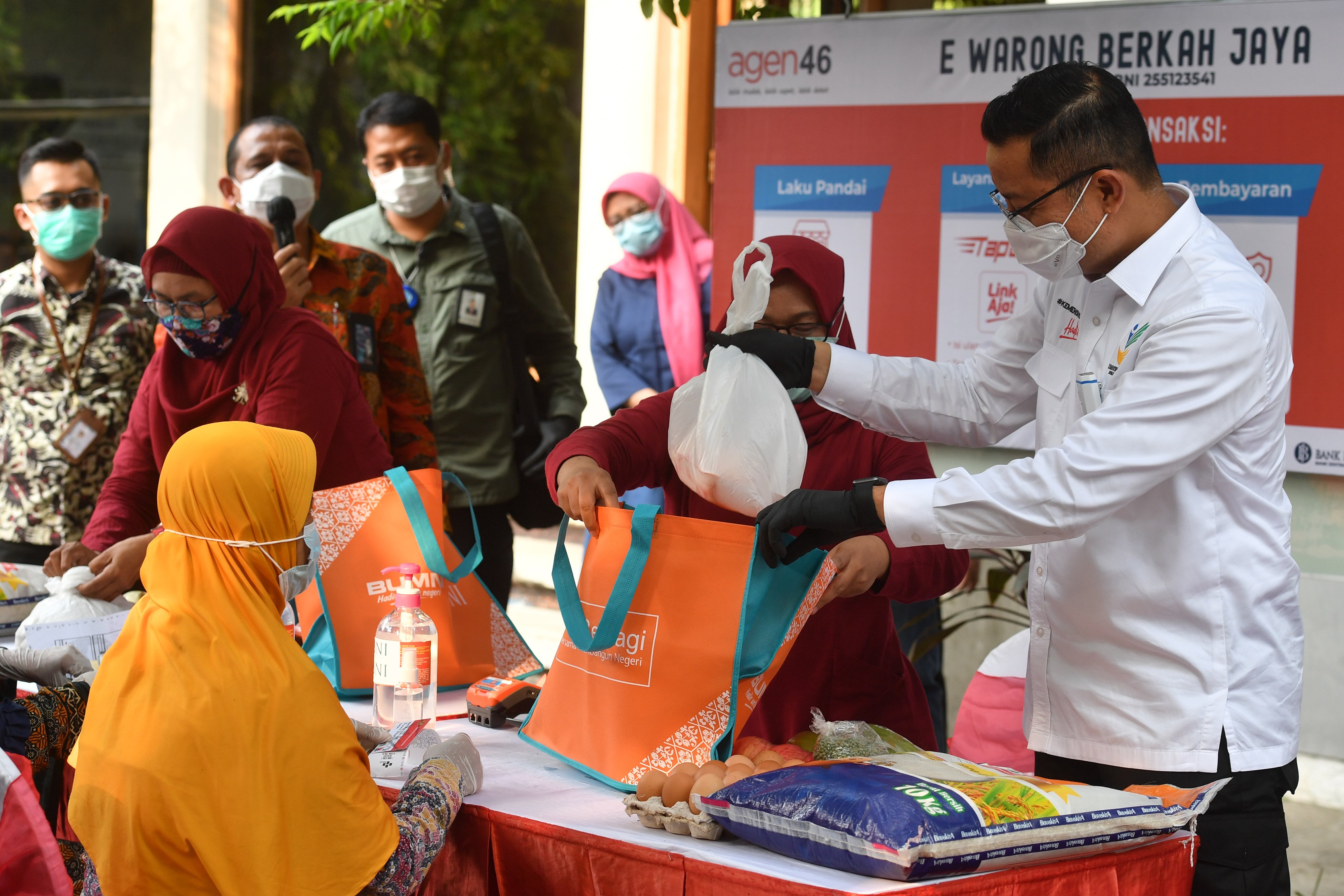 Mensos Juliari Batubara (kanan) melayani warga berbelanja kebutuhan pokok menggunakan kartu keluarga sejahtera, di Surabaya, Jatim, kemarin.