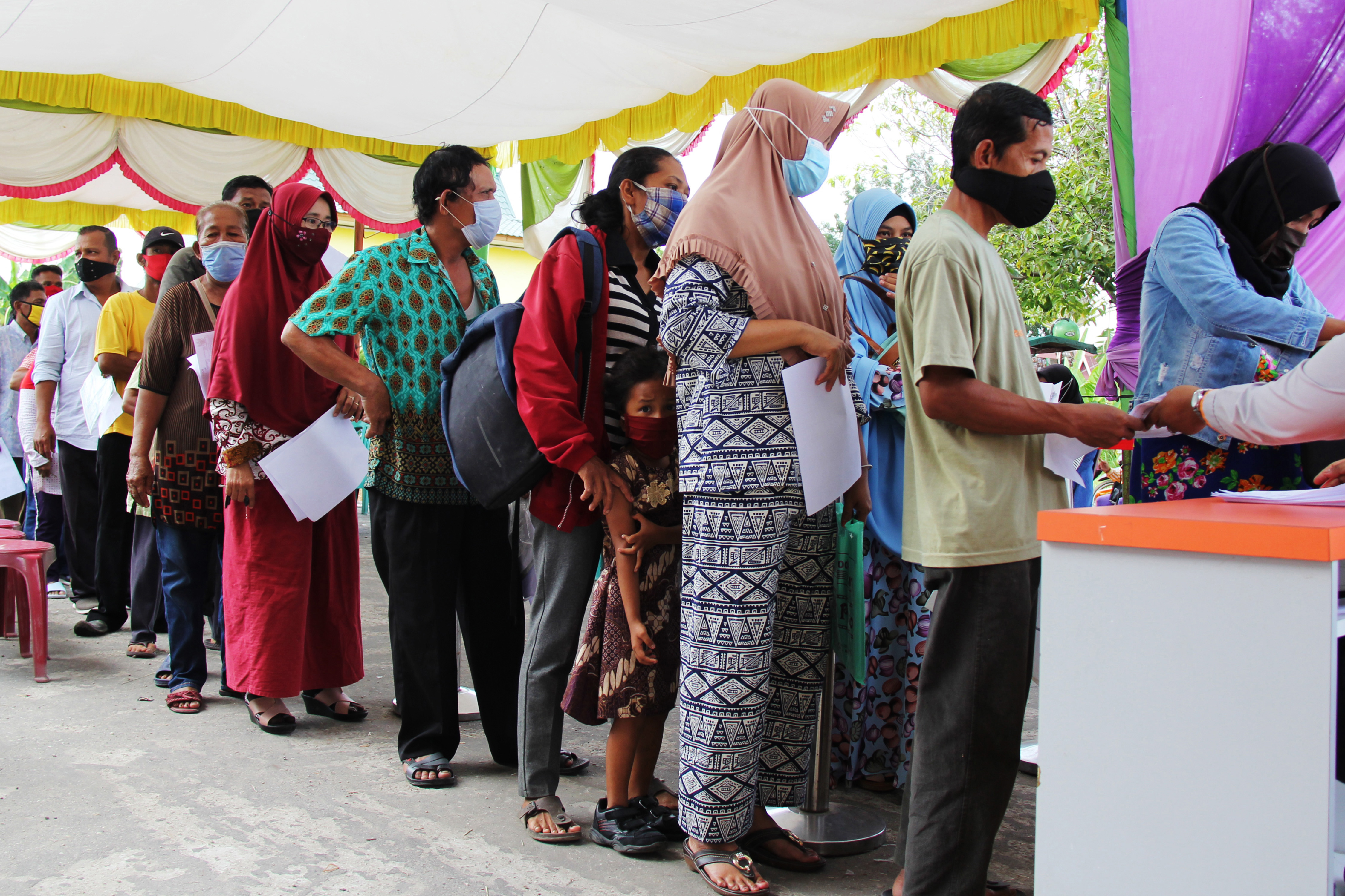 Sejumlah warga calon penerima bantuan sosial darurat pandemi covid-19 mengantre untuk mendaftarkan diri di Kantor Pos Dumai, Riau.