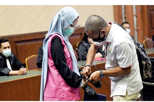 Petugas melepas borgol terdakwa Pinangki Sirna Malasari (kiri) dalam kasus dugaan suap dan gratifikasi pengurusan fatwa Mahkamah Agung (MA)