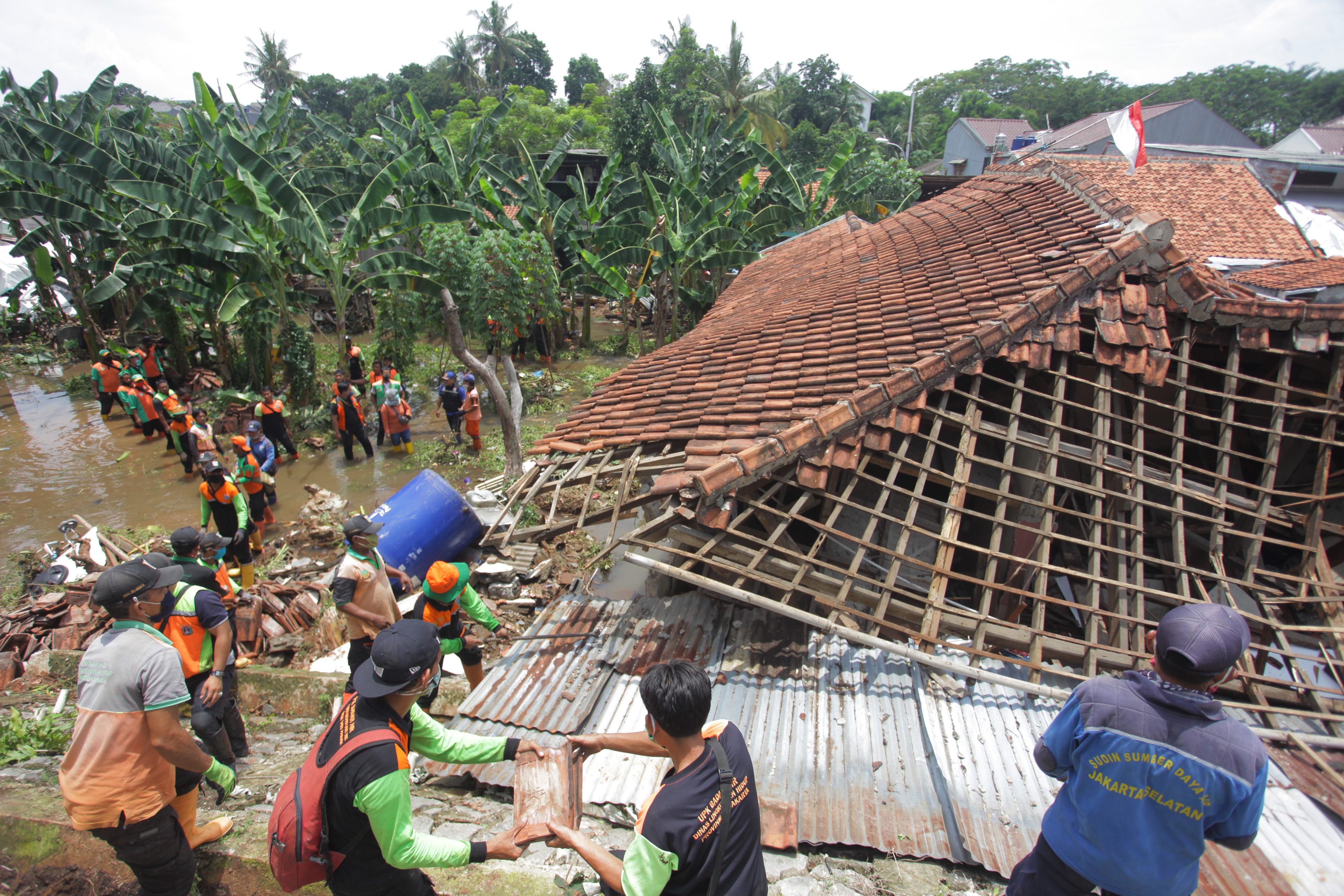 Petugas bersama relawan membenahi rumah warga yang rusak akibat tanah longsor di kawasan Ciganjur, Jakarta.