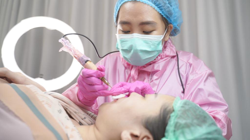 Seorang pegawai klinik kecantikan tengah merawat konsumen.