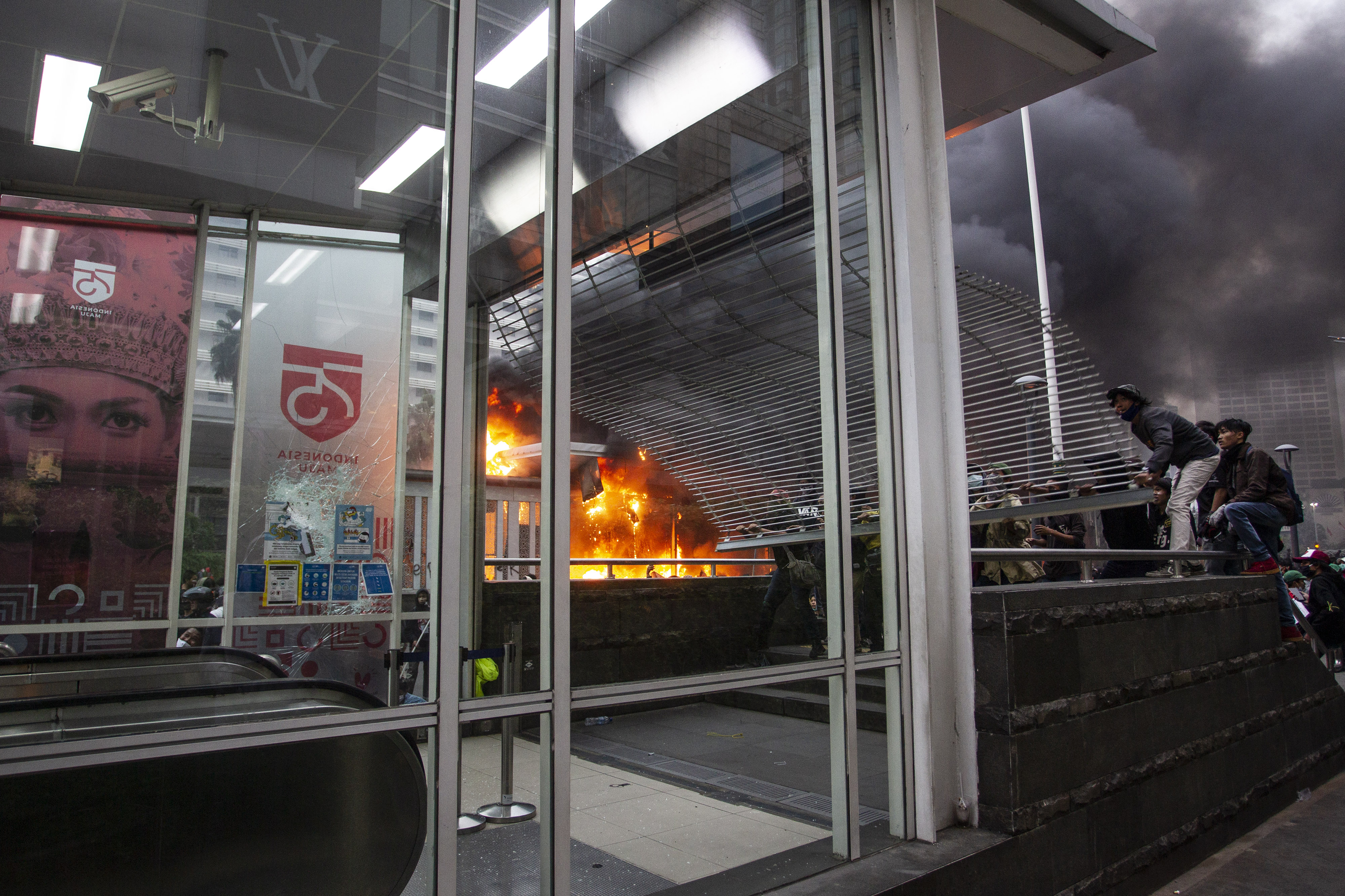 Pengunjuk rasa merusak pintu masuk Stasiun MRT Bundaran HI saat demo menolak pengesahan UU Cipta Kerja di Jakarta, Kamis (8/10).