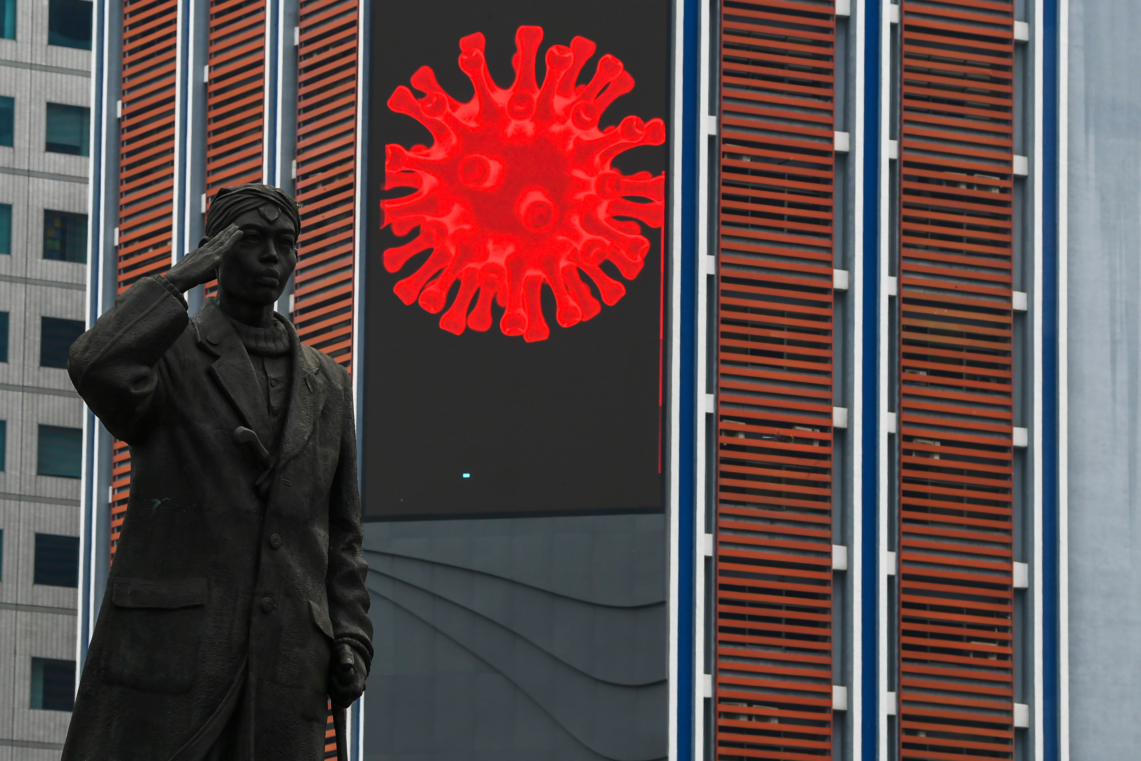  Gambar virus SARS-CoV-2 terpampang di papan elektronik imbauan tentang covid-19 di kawasan Jalan Sudirman, Jakarta.